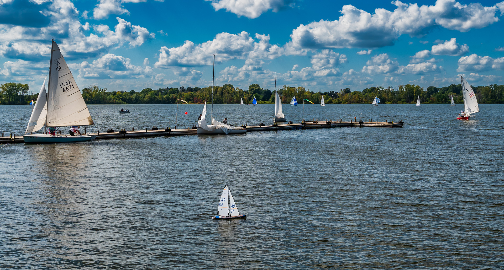 An electric-powered model sailboat travels past its larger cousins as it navigates the waters near the shoreline and docks at Hoover Sailing Club on Hoover Reservoir. My Final Photo for September 3, 2023.