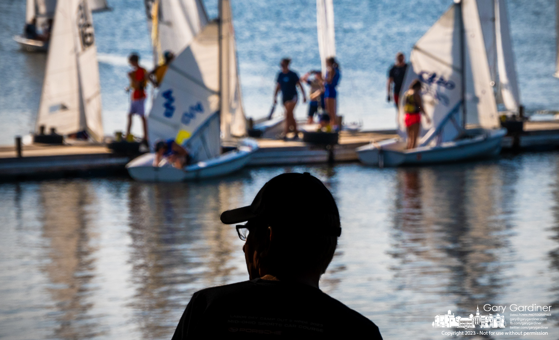 A sailor watches from shore as his younger companions prepare themselves and their boats for competition on Hoover Reservoir. My Final Photo for September 21, 2023.