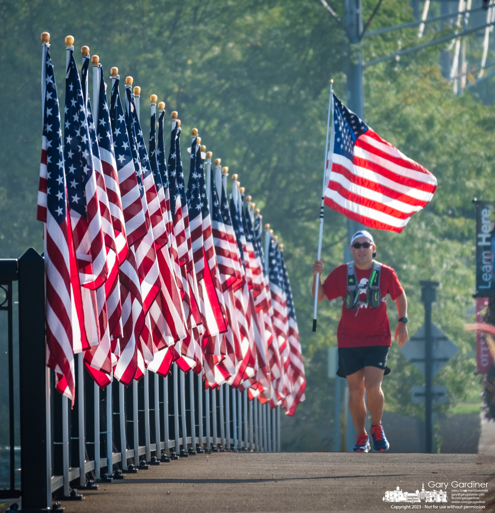 Ryan Garcia carries the American flag across the Main Street Bridge as he begins his run marking the anniversary of the 9/11 terrorist attacks on the World Trade Center. My final Photo for September 11, 2023.