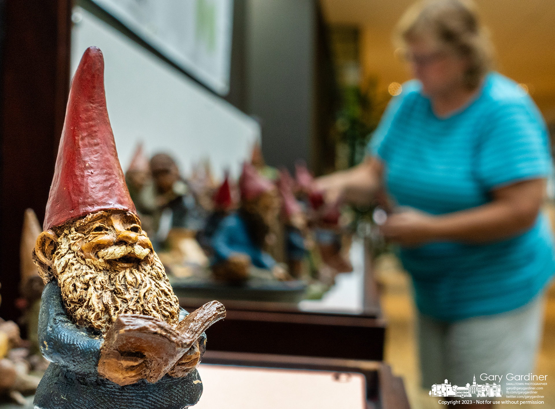Krista Chrisman arranges her 312 Tom Clark pecan resin gnome figurines in the display cases at the Westerville Public Library where they will be on exhibit for several weeks. My Final Photo for September 5, 2023.