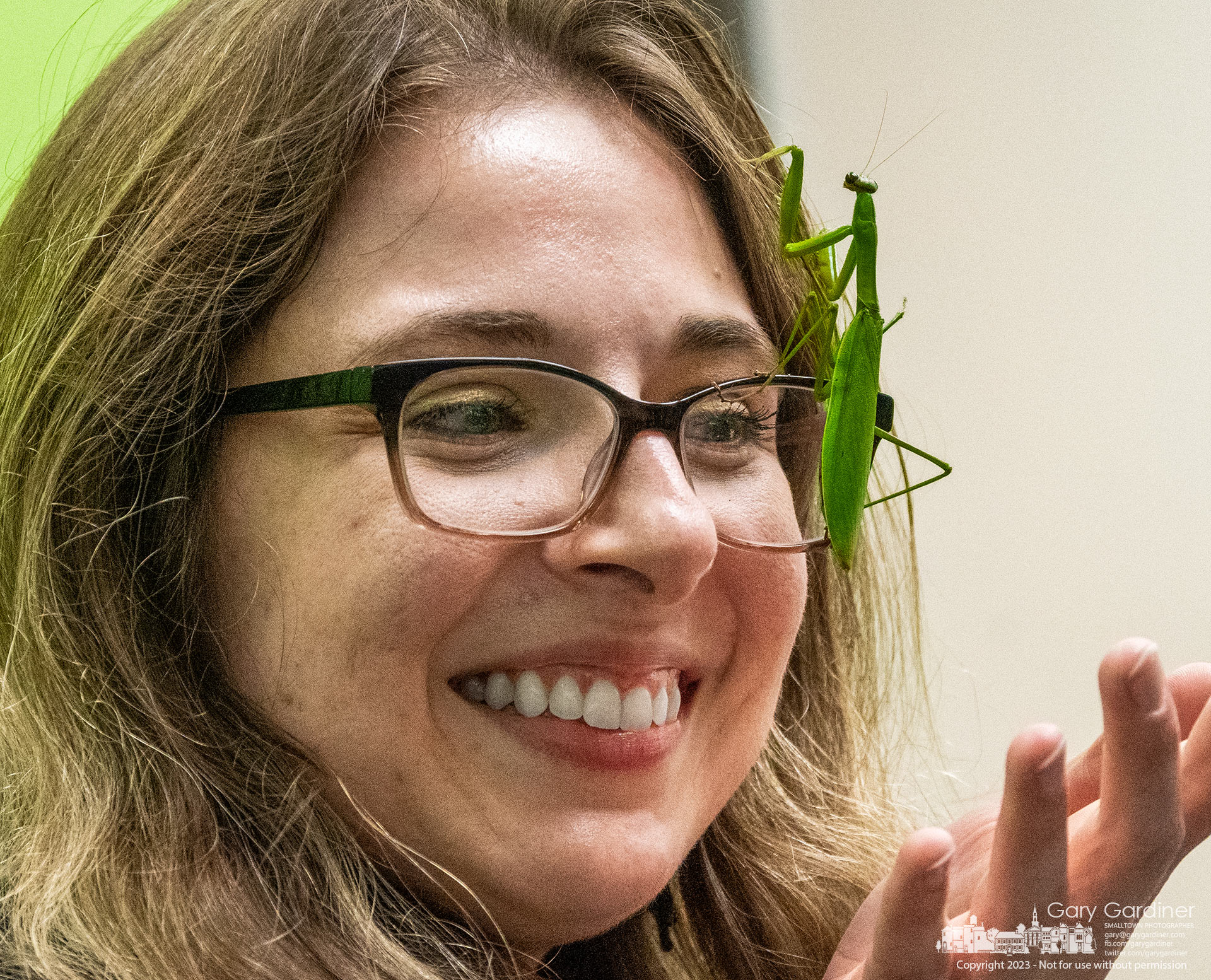 A praying mantis intended to mesmerize children attending BUG OUT insect, arachnid, and centipede show at the Westerville Library climbs the face of a librarian who chose to help manage the insect during a break in the show. My Final Photo for October 14, 2023.