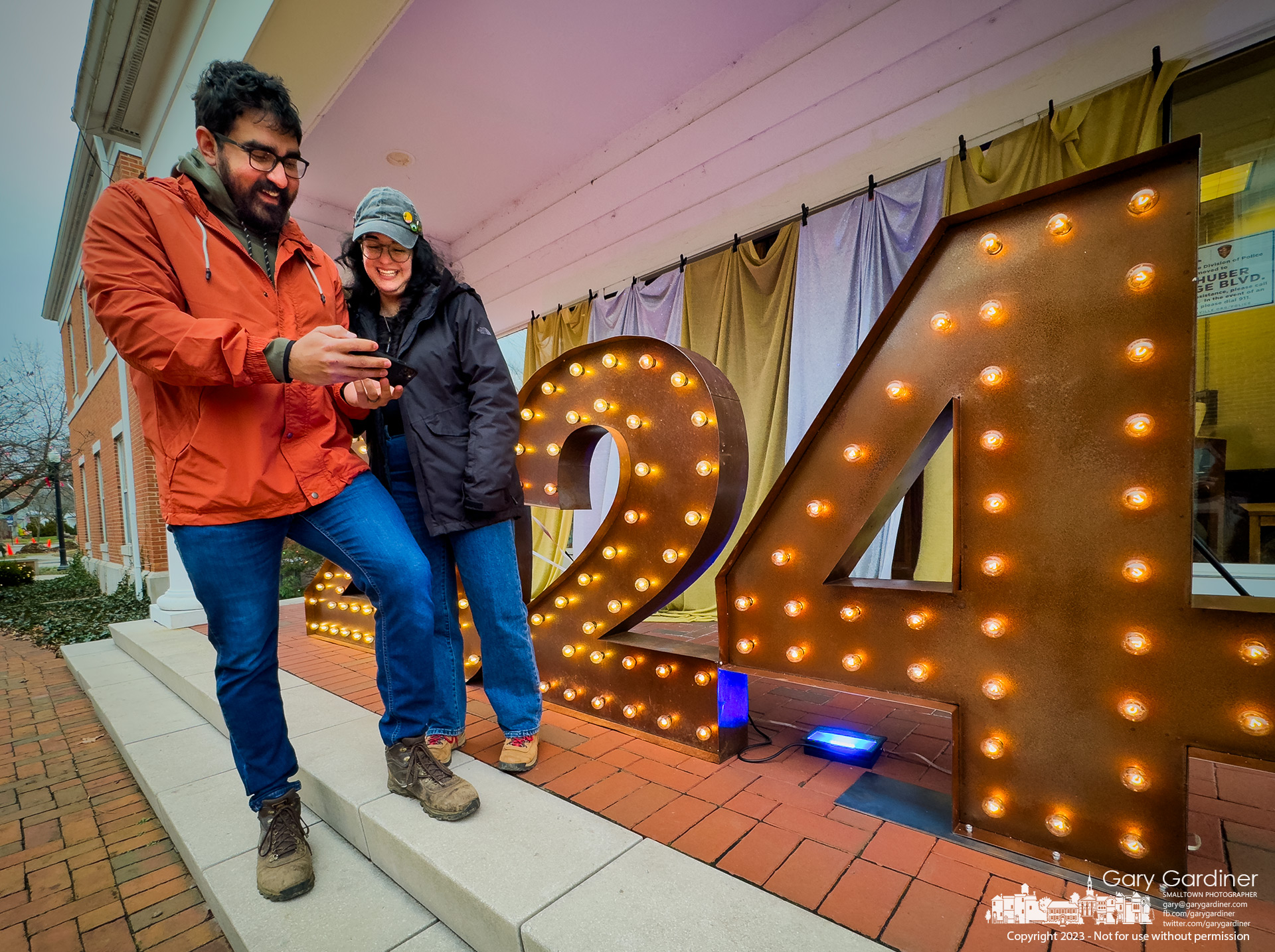 A couple enjoys the photo taken of them posing in front of the lighted 2024 sign at city hall in Uptown Westerville. My Final Photo for December 31, 2023.