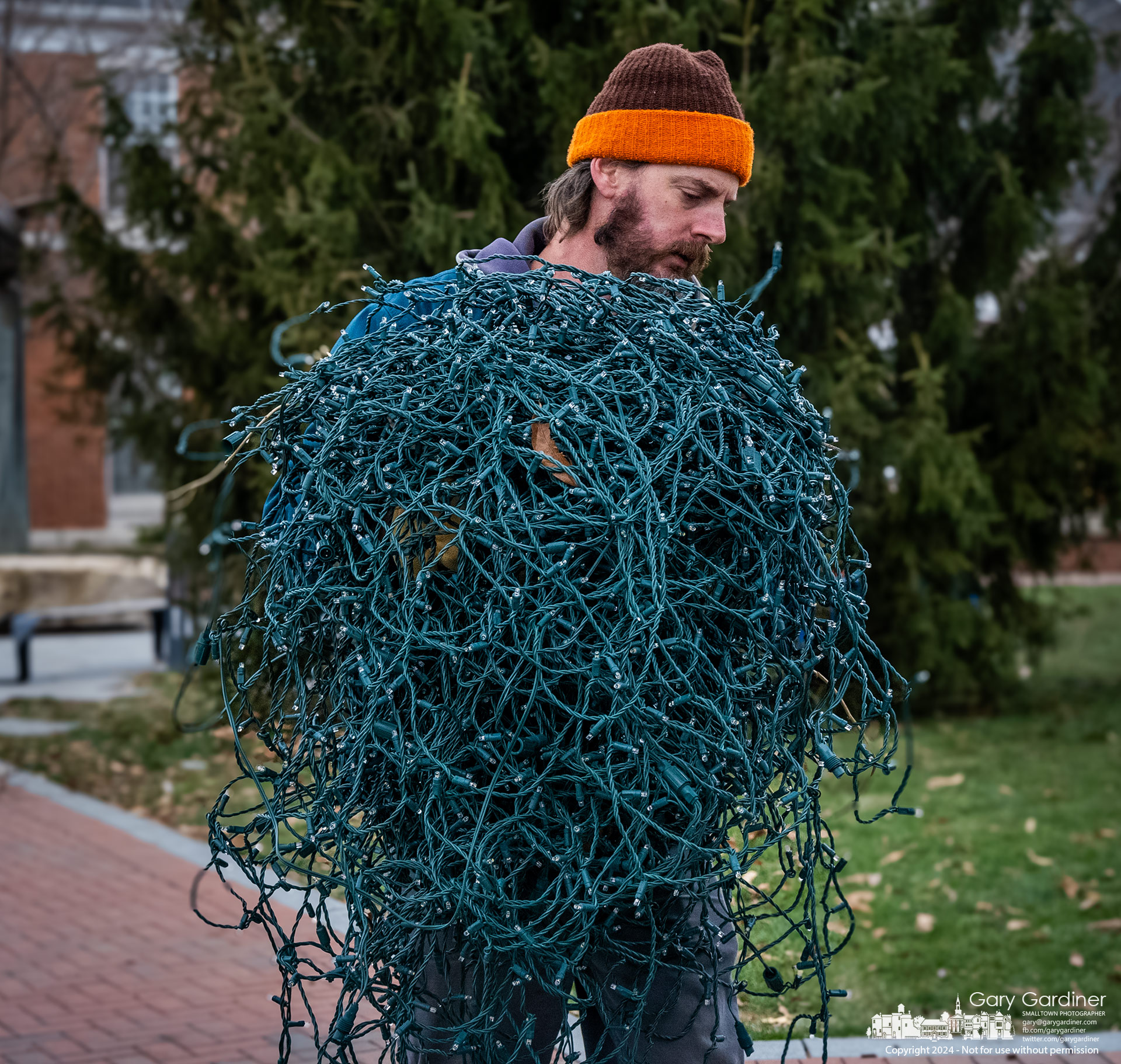 Westerville Parks and Recreation worker carries a ball of LED lights removed from the city Christmas tree in front of city hall officially marking the end of the season for the city. My Final Photo for December 2, 2023.