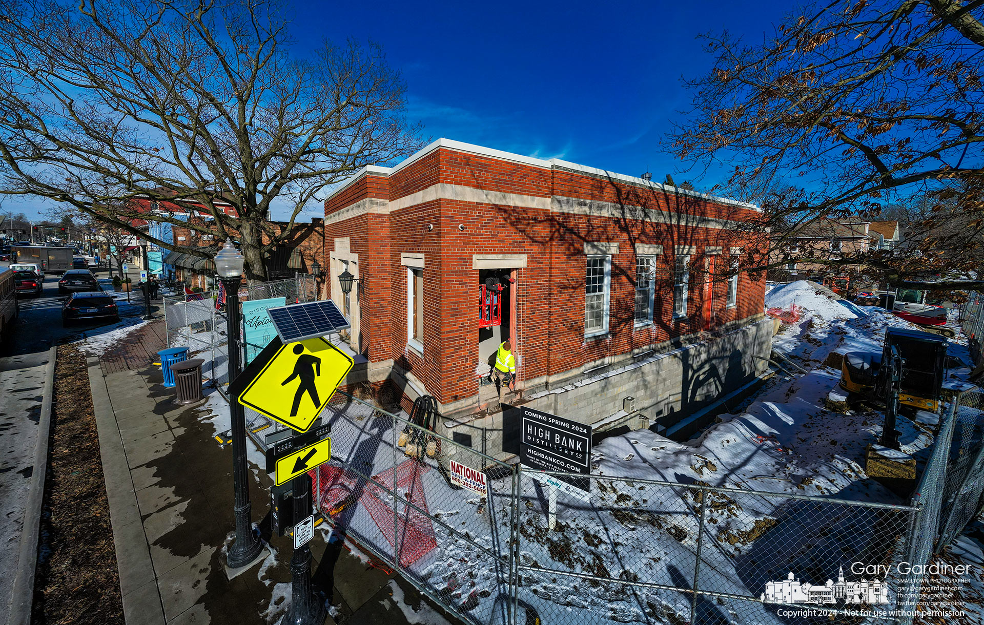 Workers prepare to put a temporary covering over the new doorway cut into the Winter Street side of the old post office in Uptown as it is converted from the detective bureau for the police department to the High Bank Distillery restaurant across the street from a sculptor about Westerville's history in the Prohibition movement. My Final Photo for January 22, 2024.