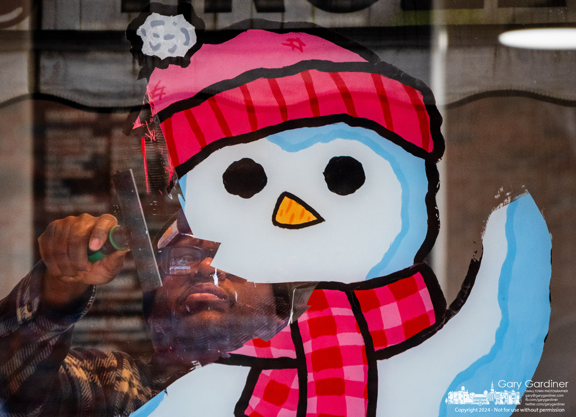 The snowman painted in the widow of Whit's in Uptown Westerville appears to be giving a farewell wave as he is scraped from the front window clearing the storefront of all signs of Christmas and winter as it prepares to offer Valentine's Day specials. My Final Photo for January 23, 2024.