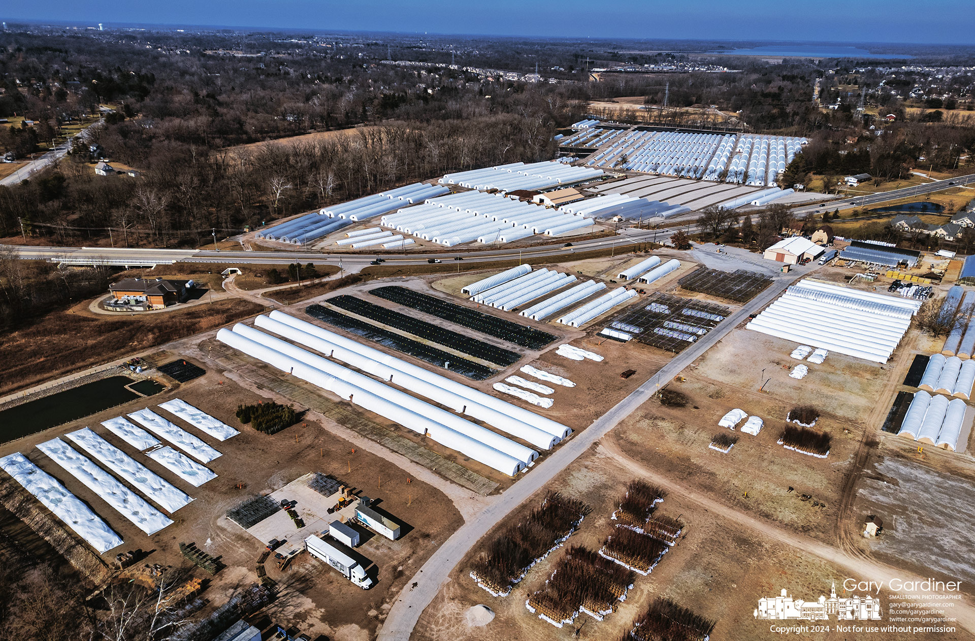 Acorn Nursery's greenhouses covered in plastic for the winter sit along Alum Creek just below the Alum Creek Park dam, in the background. My Final Photo for February 12, 2024.