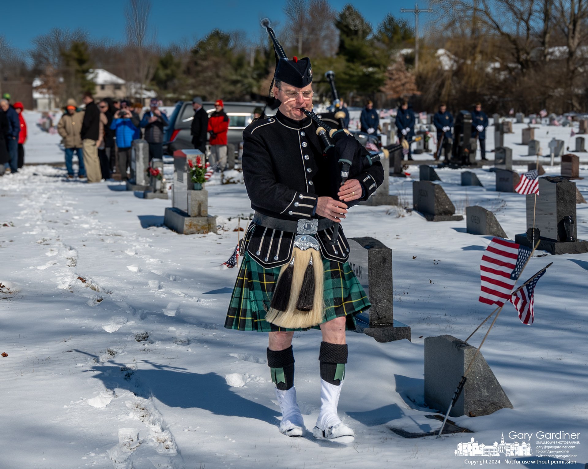 A bagpiper treads away from the American Legion Honor Guard and the family and friends of 97-year-old Donald Conard, World War II veteran and survivor of the Japanese strike on the USS Franklin CV-13, after his funeral Saturday at Blendon Cemetery. My Final Photo for February 24, 2024. 