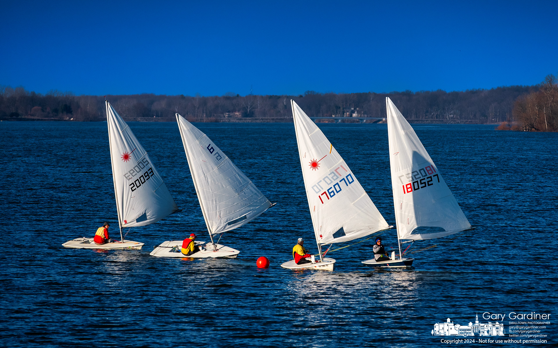 With the Red Bank bridge at the horizon and a minimum of four boats to race on a winter day, a quartet of sailors from the Hoover Sail Club pass the final buoy on the final race Sunday afternoon. My Final Photo for February 11, 2024.
