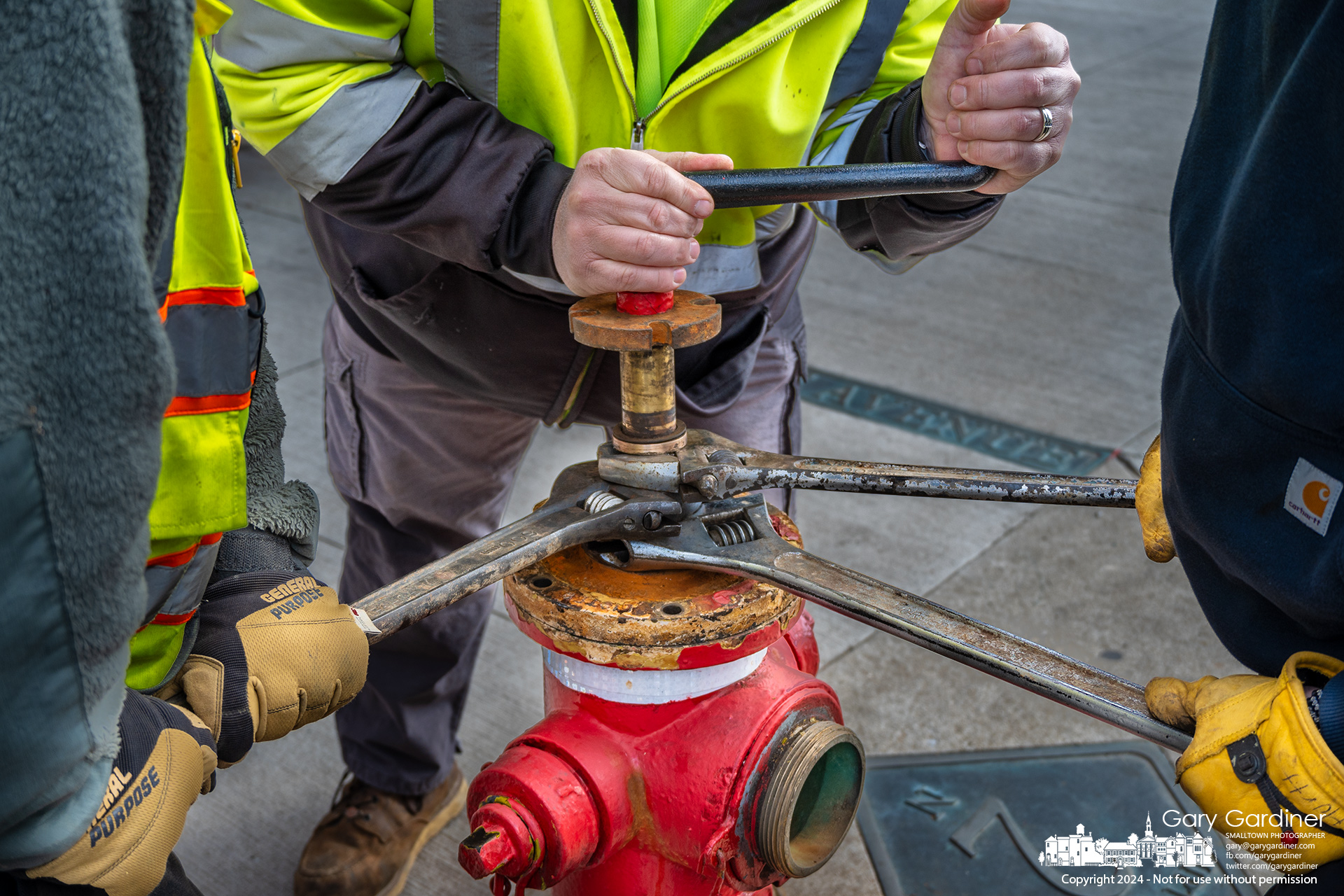 City service workers use three crescent wrenches for leverage and another to rotate a broken section of the fire hydrant in front of Westerville Antiques to make repairs after it failed during a routine inspection last week. My Final Photo for February 13, 2024.