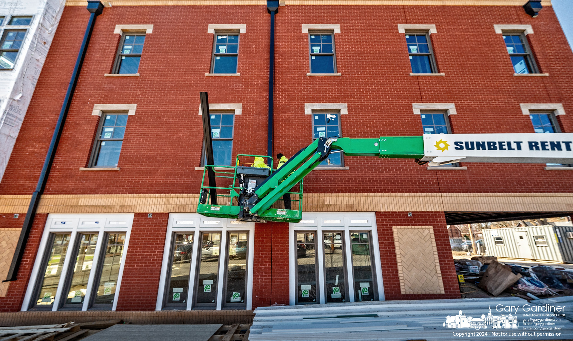 Metalworkers install downspouts on the east side of the new multi-use building being built on West College with four apartments on the top two floors and plans to build the Ampersand restaurant on the first floor. My Final Photo for March 11, 2024.