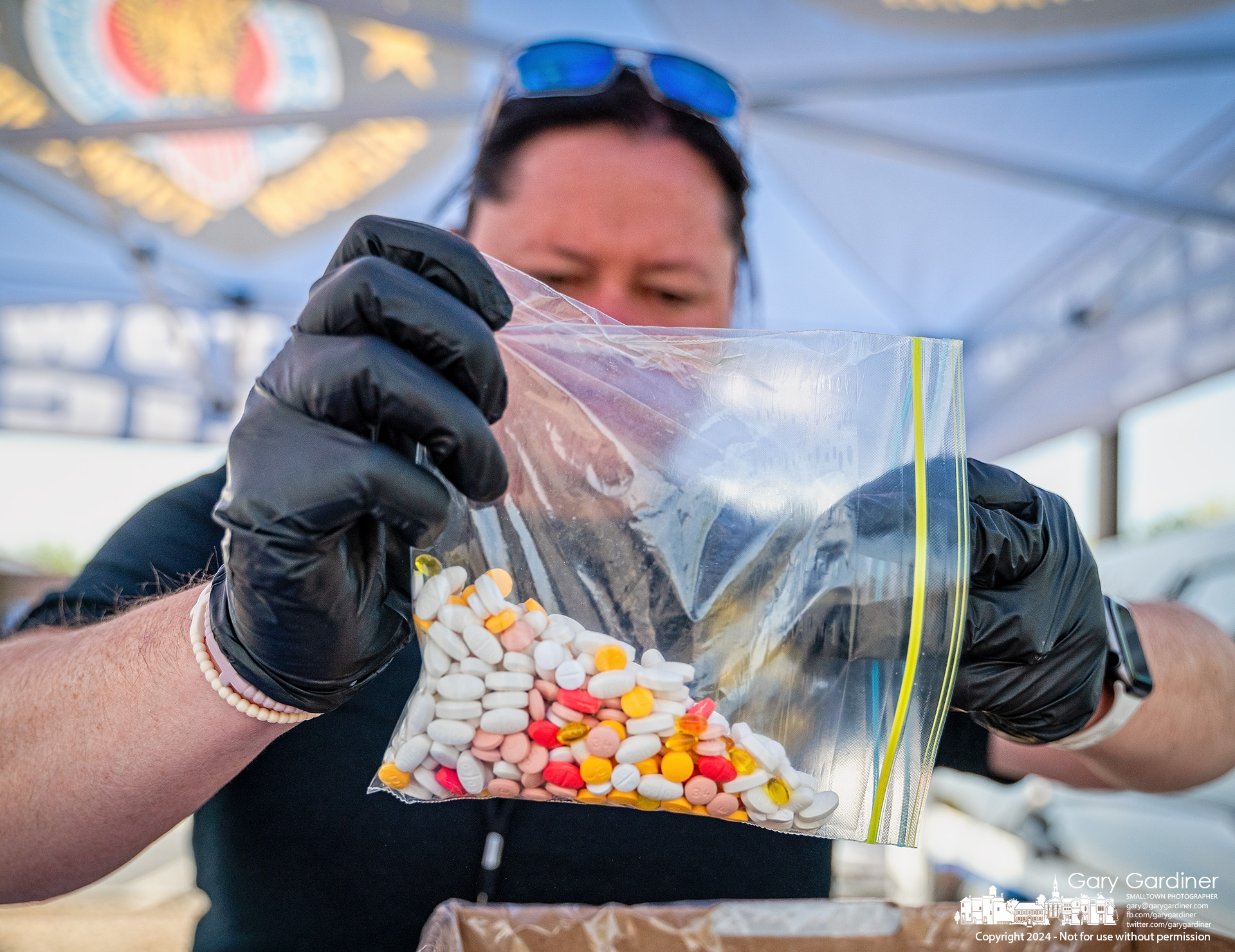 A Blendon Township police officer empties a baggie filled with prescription drugs into a holding container during National Drug Take Back Day. My Final Photo for April 27, 2024.