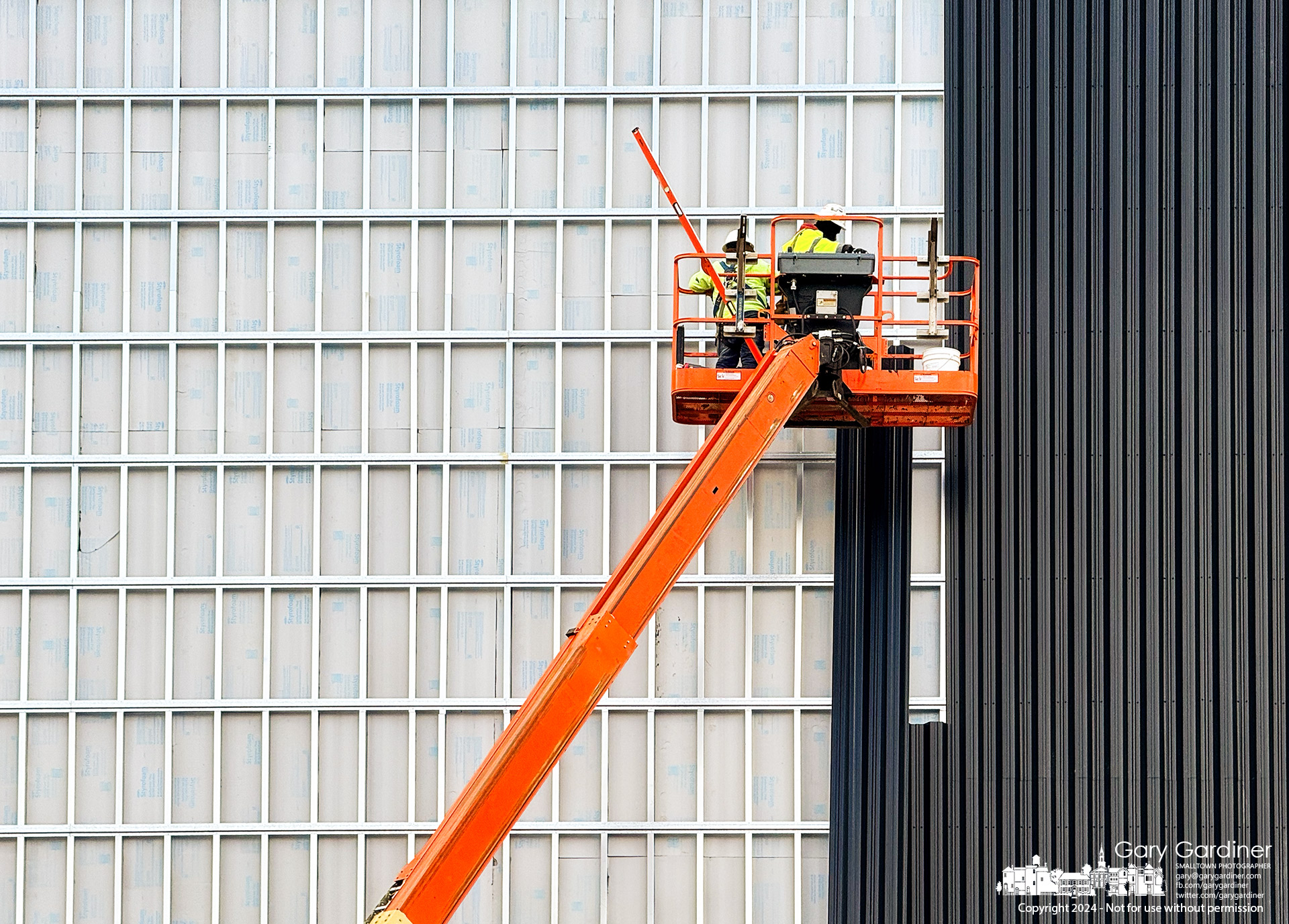 Workers install black metal panels on the outside of Rock City Church's new sanctuary and building being built on Gemini Parkway in Columbus. My Final Photo for April 5, 2024.