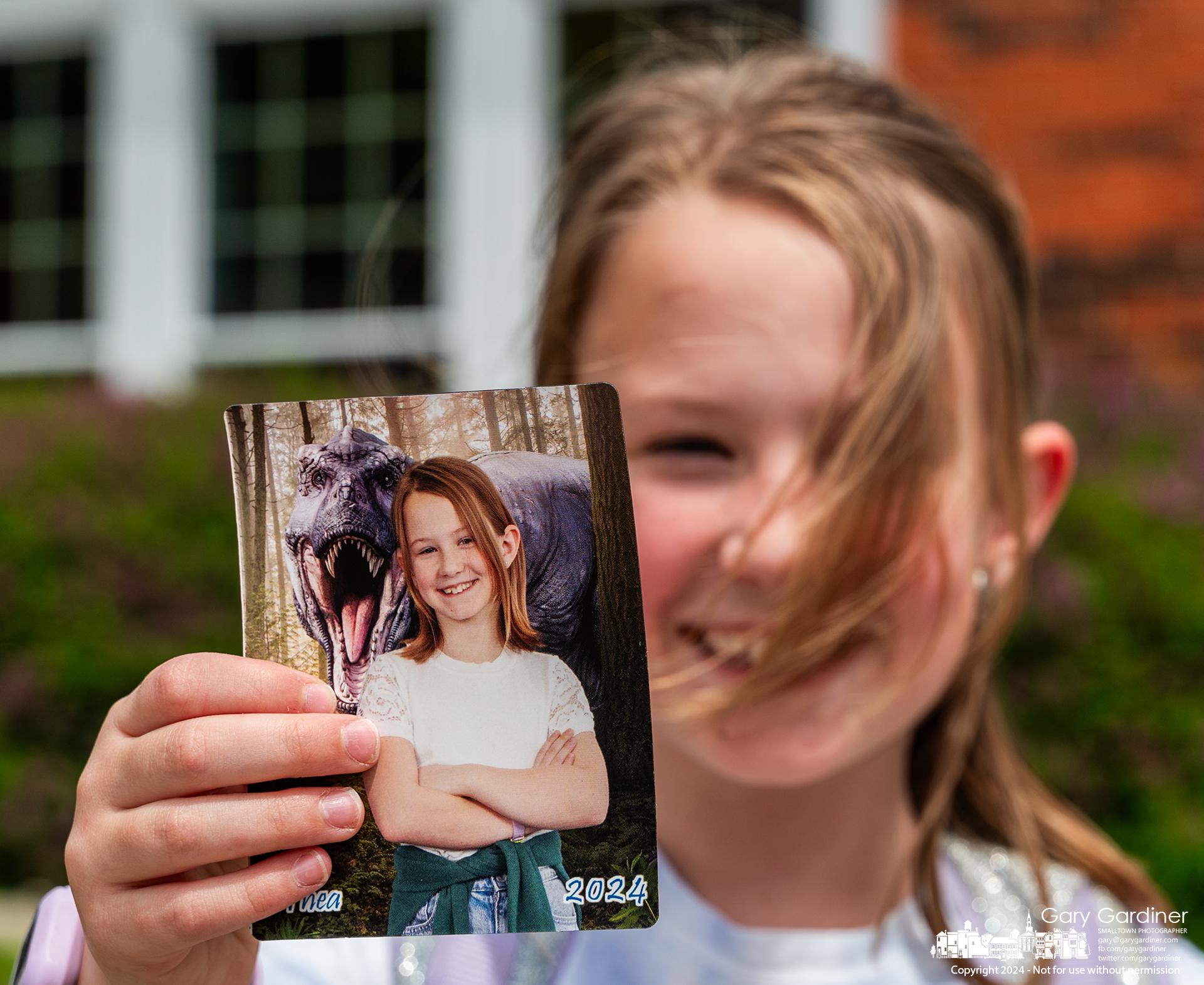 Thea Willemstein, 9, proudly shows off her Hanby Elementary third grade class portrait with a T-Rex as the background. My Final Photo for April 26, 2024.