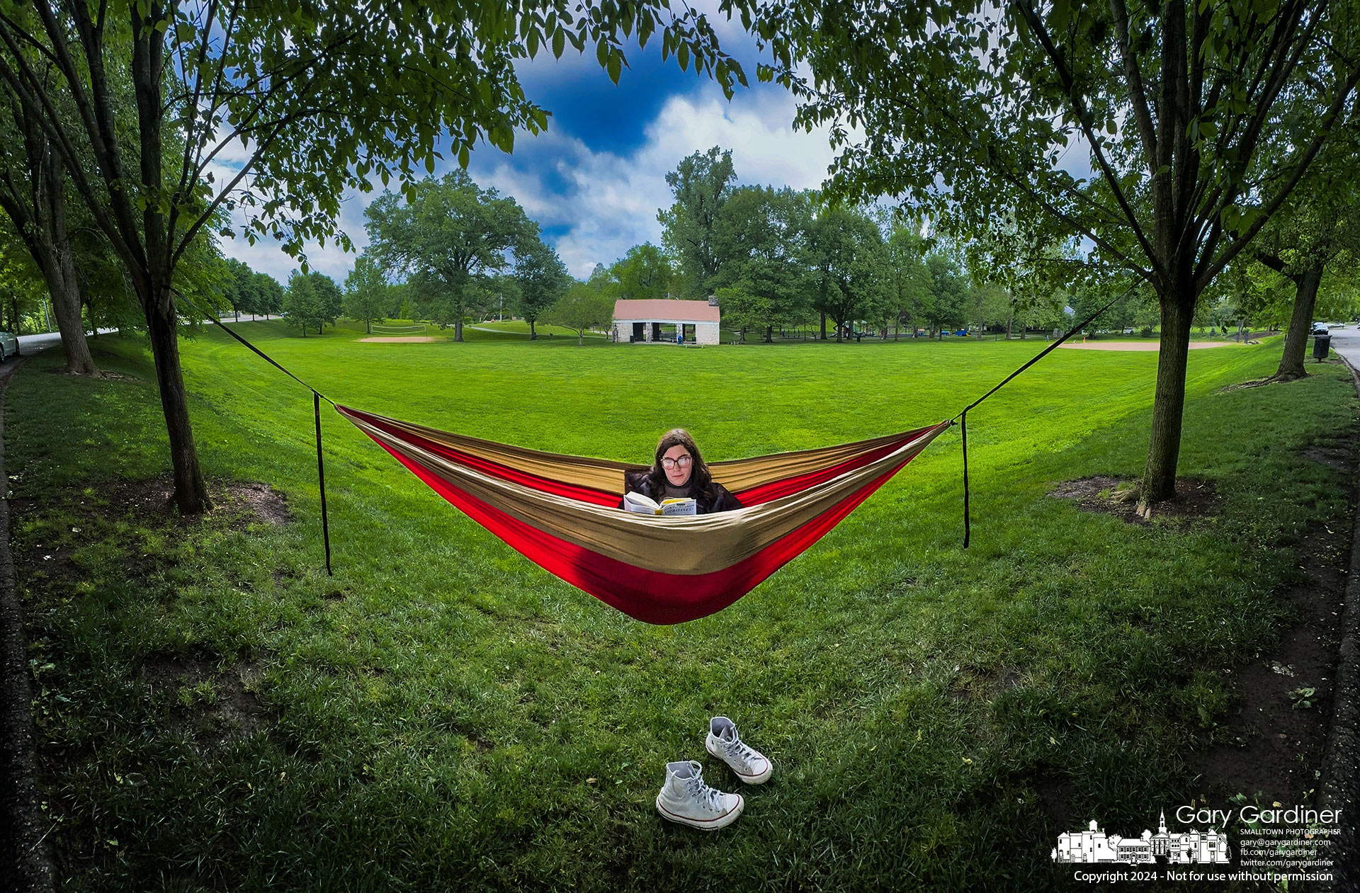Aiva Jacobus relaxes with a book on her hammock strung between two trees lining the driveway at Alum Creek Park North in Westerville. My Final Photo for May 15, 2024.