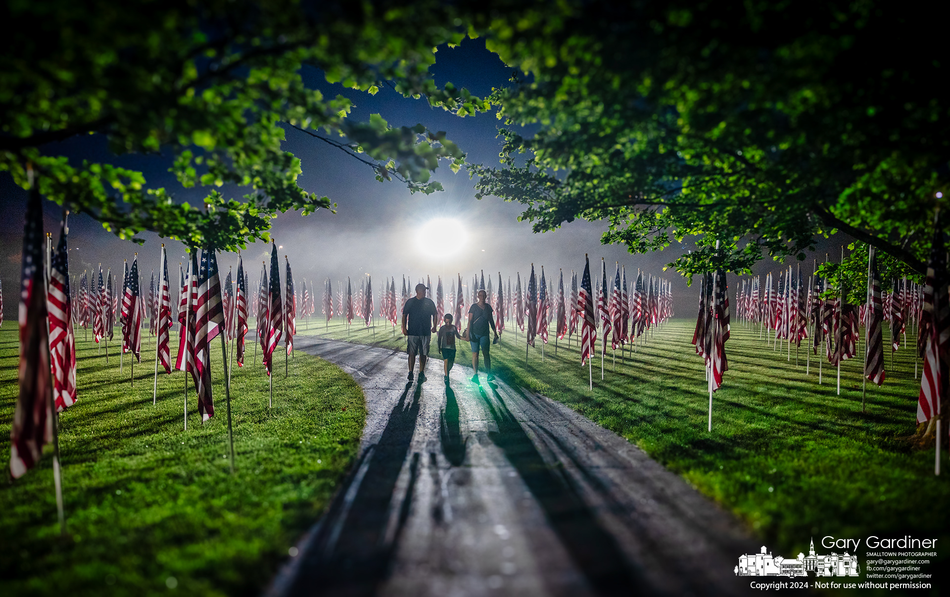A family walks in a light fog through the more than 3,000 flags displayed at Field of Heroes in Westerville for Memorial Day weekend. My Final Photo for May 24, 2024.