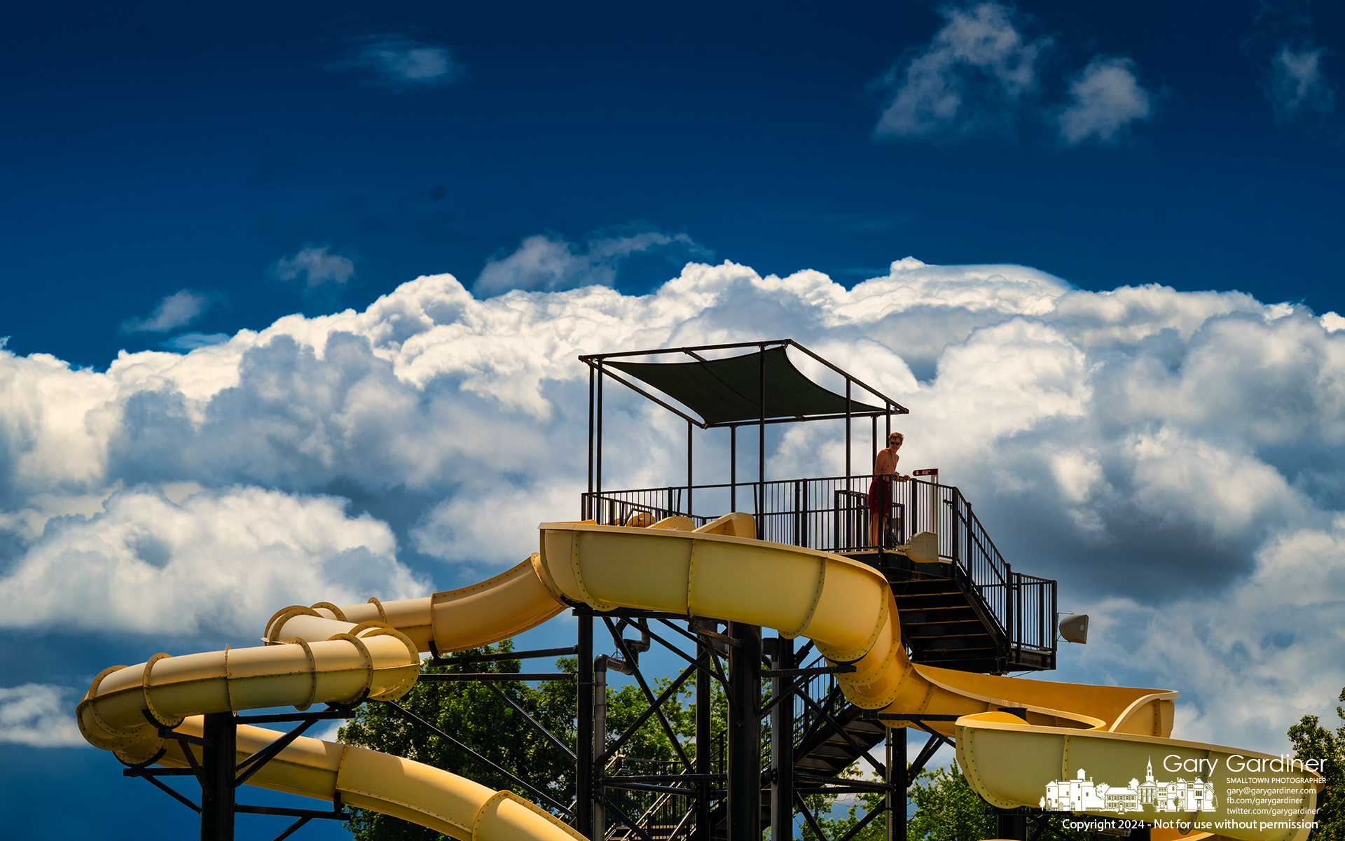 A lifeguard at Highlands Pool watches over his charges at the water slide as an afternoon storm slides past Westerville. My final Photo for May 29, 2024.