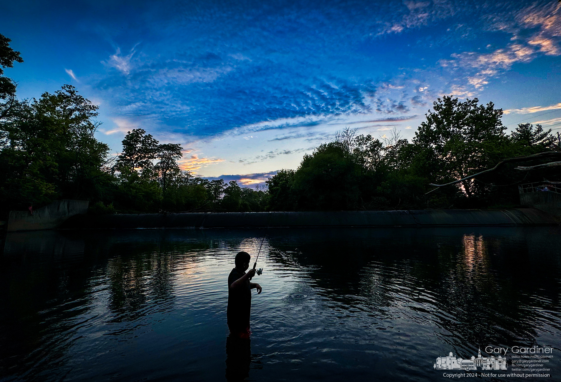 A young angler wades into the water and prepares his line for casting below the lowhead dam at Alum Creek Park North in Westerville late on a late, hot summer afternoon. My Final Photo for June 19, 2024.