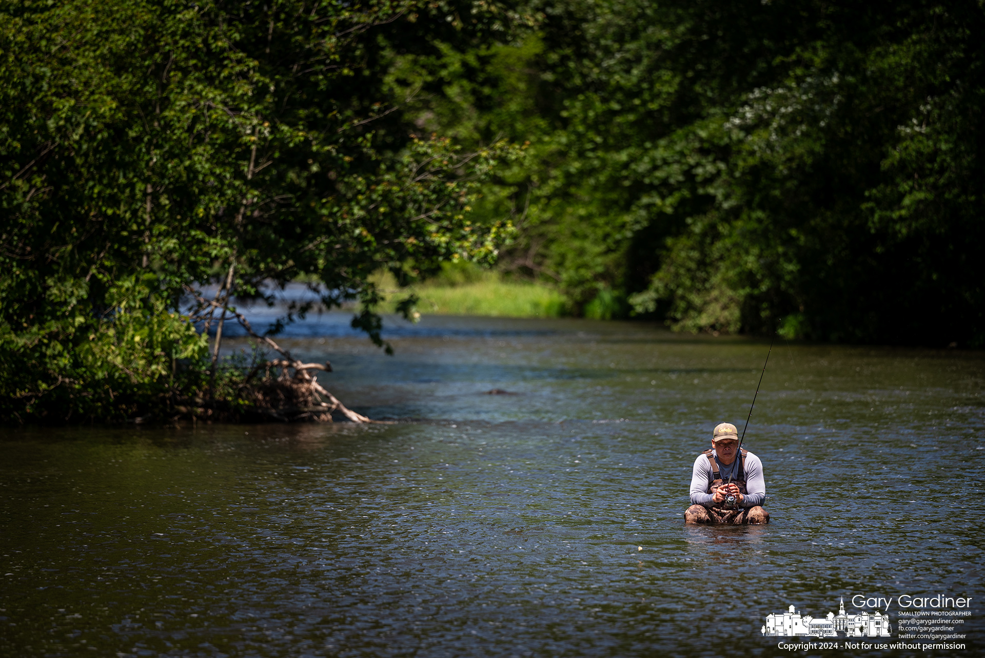 A fisherman sits on an upended five-gallon-bucket to fish the center of the Big Walnut Creek stream below Hoover Dam. My Final Photo for June 13, 2024.