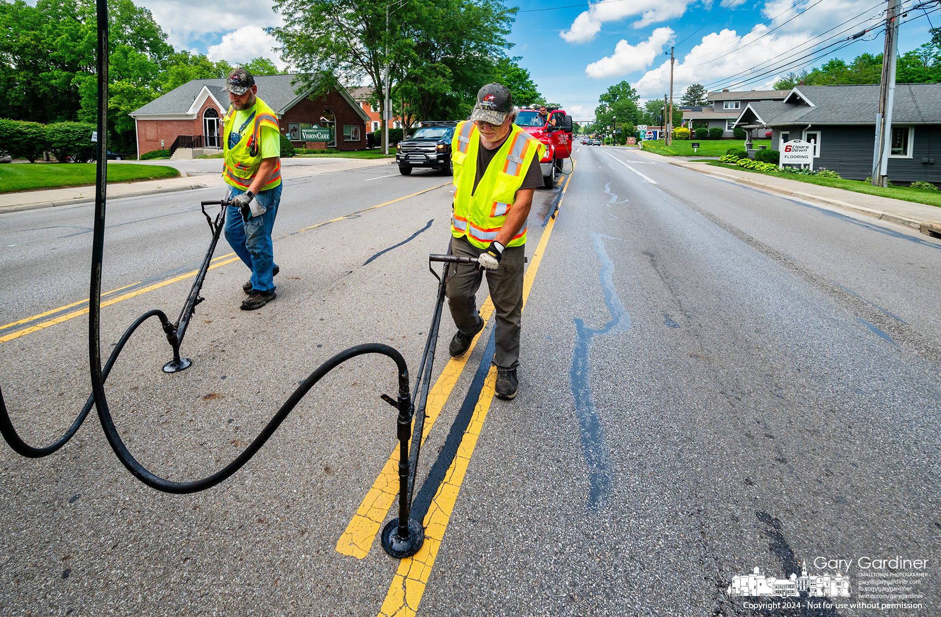 Workers apply a hot tar mixture to cracks in the asphalt on South State Street as part of a maintenance program to prevent further cracking and erosion of the heavily traveled road. My Final Photo for June 3, 2024.