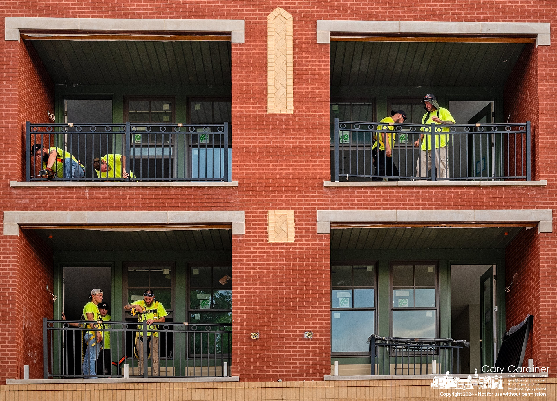 Railings for the four new apartments in a multi-use building are fastened into place on West College, where Ampersand restaurant will occupy the first floor. My Final Photo for July 15, 2024.