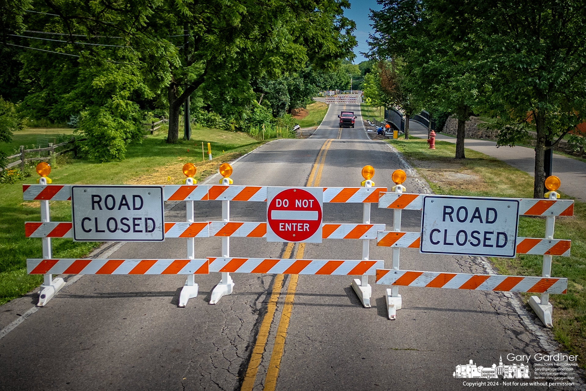 Road-closed barriers mark both sides of the creek where the city is replacing a culvert on Hempstead Road, causing the road to be closed until the end of summer. My Final Photo for July 8, 2024.v