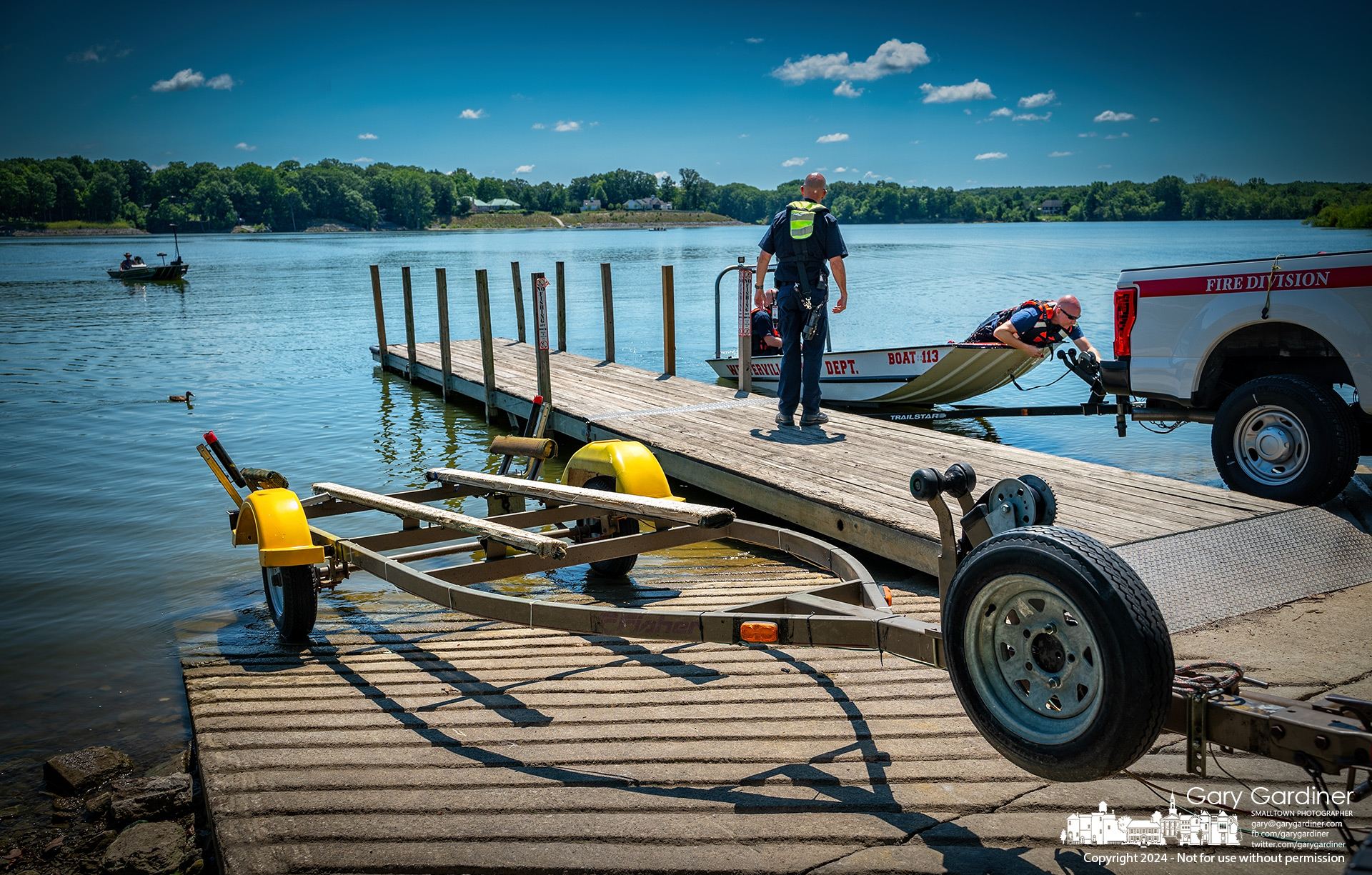 Westerville firefighters load their rescue boat on its trailer after finding a fisherman, at left, rear, who launched his boat from the trailer in the foreground and then absentmindedly went fishing, leaving the trailer and his running truck on the boat ramp on Hoover Reservoir Thursday. My Final Photo for July 11, 2024.