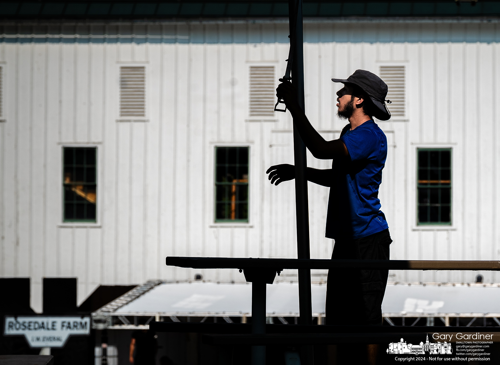 A pole puller aligns the center support for the tent built atop the small hill next to Everal Barn at Heritage Park for this weekend's Westerville Arts and Music Festival. My Final Photo for July 12, 2024.