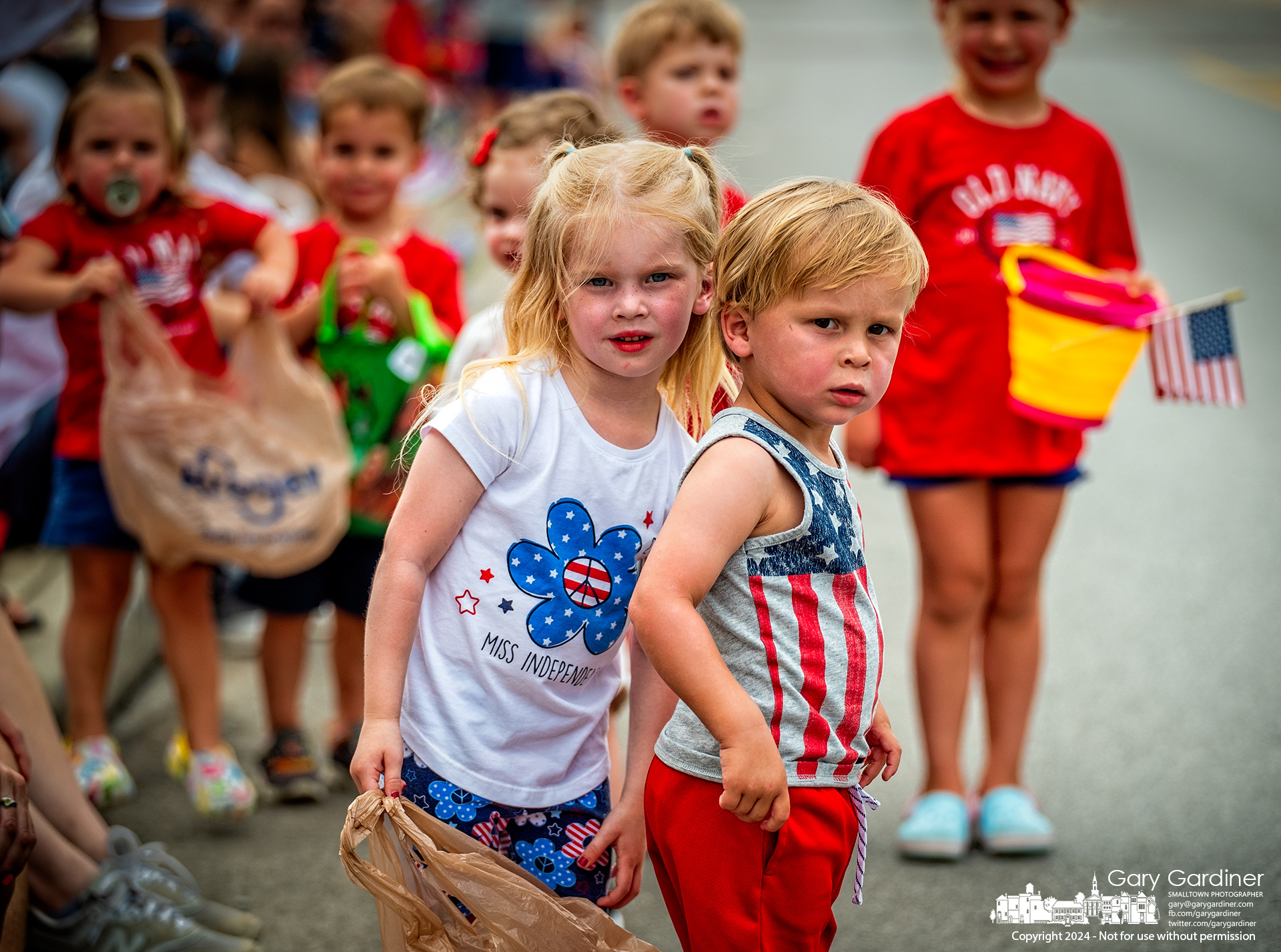 Brother and sister share their perfect location as they stare down State Street looking for the next group tossing candy in the July 4th parade in Uptown Westerville. My Final Photo for July 4, 2024.