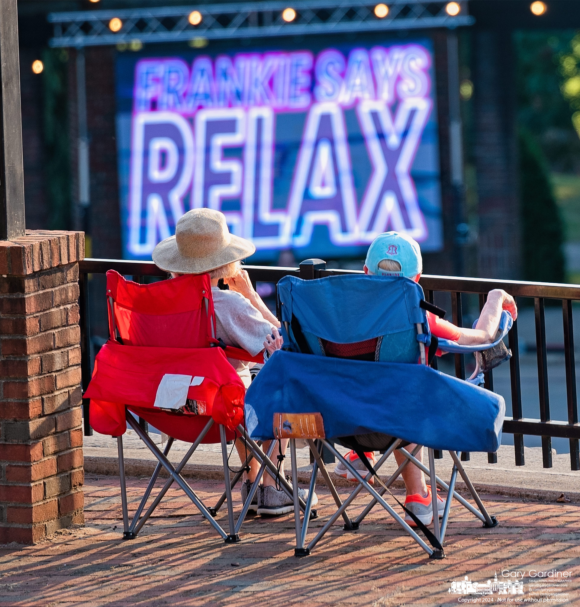 A couple settles into their folding lawn chairs following instructions from the New Wave Nation performing at the Alum Creek Amphitheater Sunday night. My Final Photo for August 25, 2024.