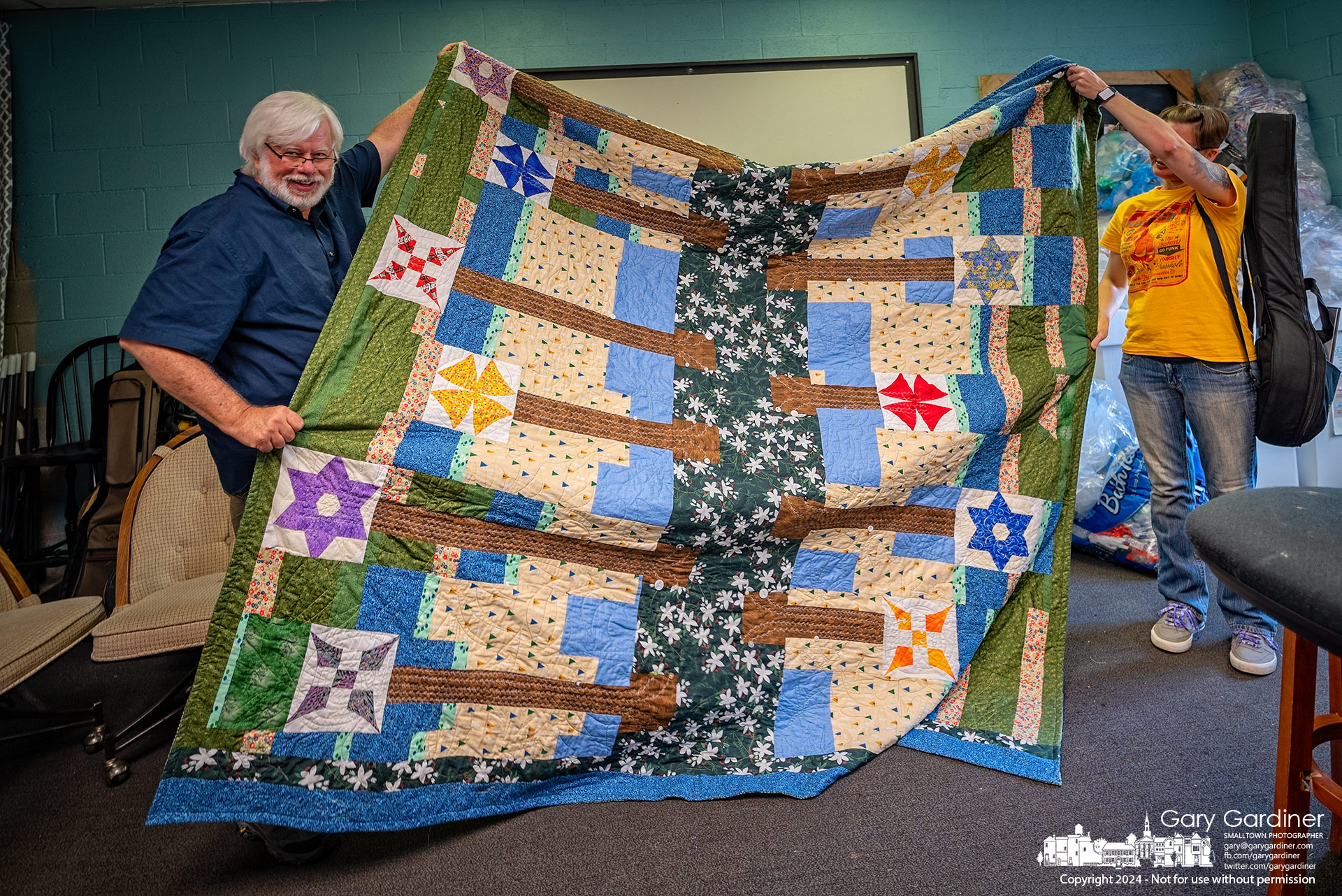 Gary Puckett displays a guitar head quilt given to him by one of his students, marking their time together. My Final Photo for August 21, 2024.