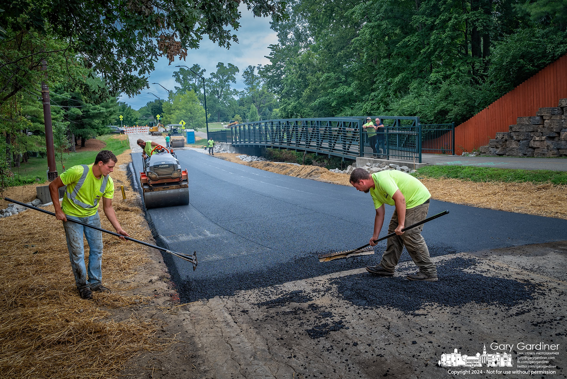 Workers level fresh asphalt at the seam connecting a new road surface to the old at the new culvert and bridge spanning a creek on Hempstead Road in Westerville. My Final Photo for August 8, 2024.