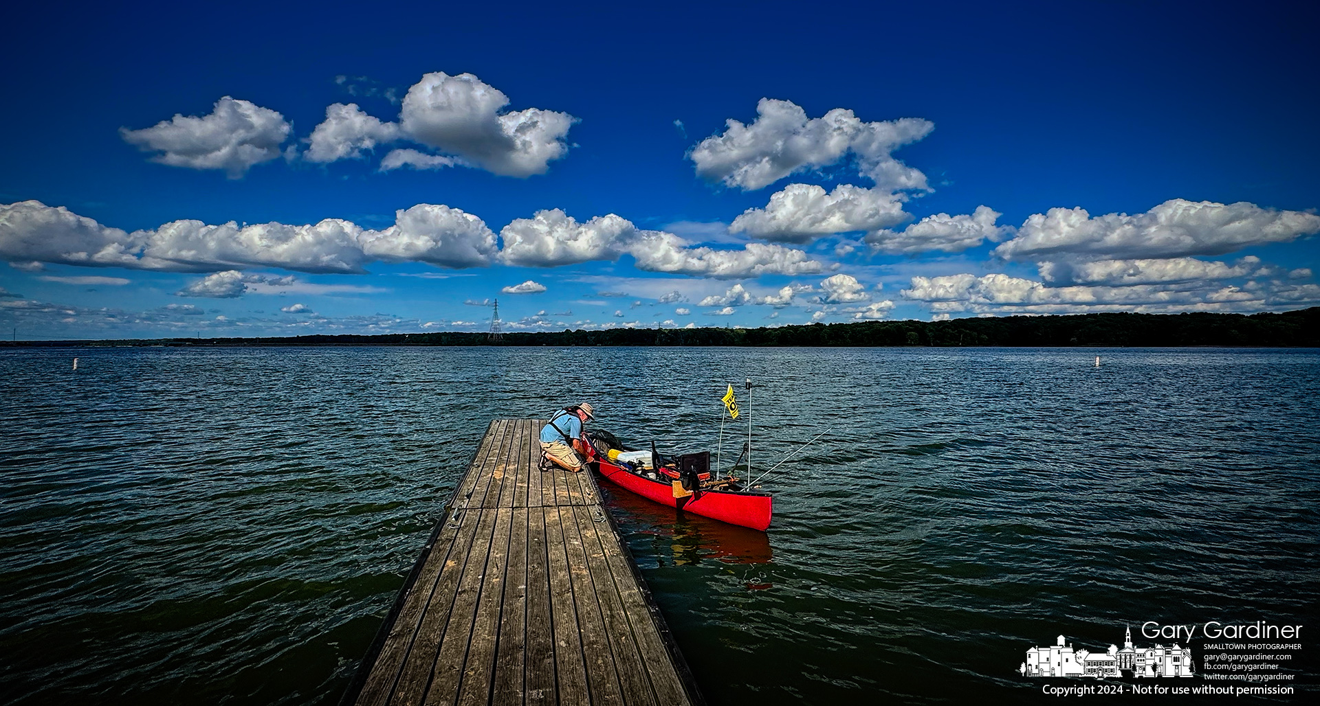 A fisherman readies his canoe for an afternoon fishing on Hoover Reservoir under a cumulus cloud-filled blue sky. My Final Photo for August 12, 2024.