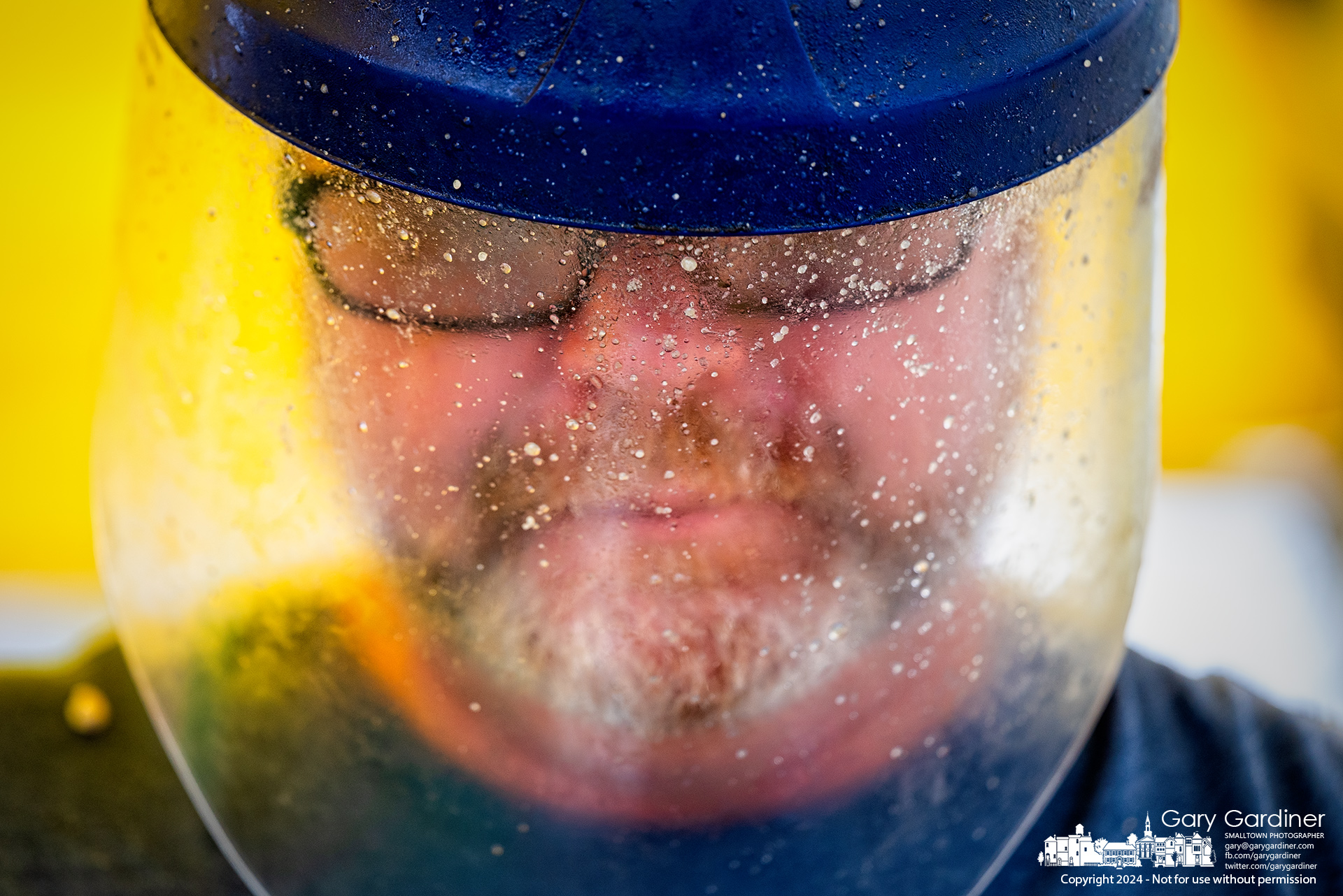 A splattering of popcorn, oil, and sugar coats the face shield of the head kettle popcorn popper at the Saturday Farmers Market in Uptown Westerville. My Final Photo for August 31, 2024.