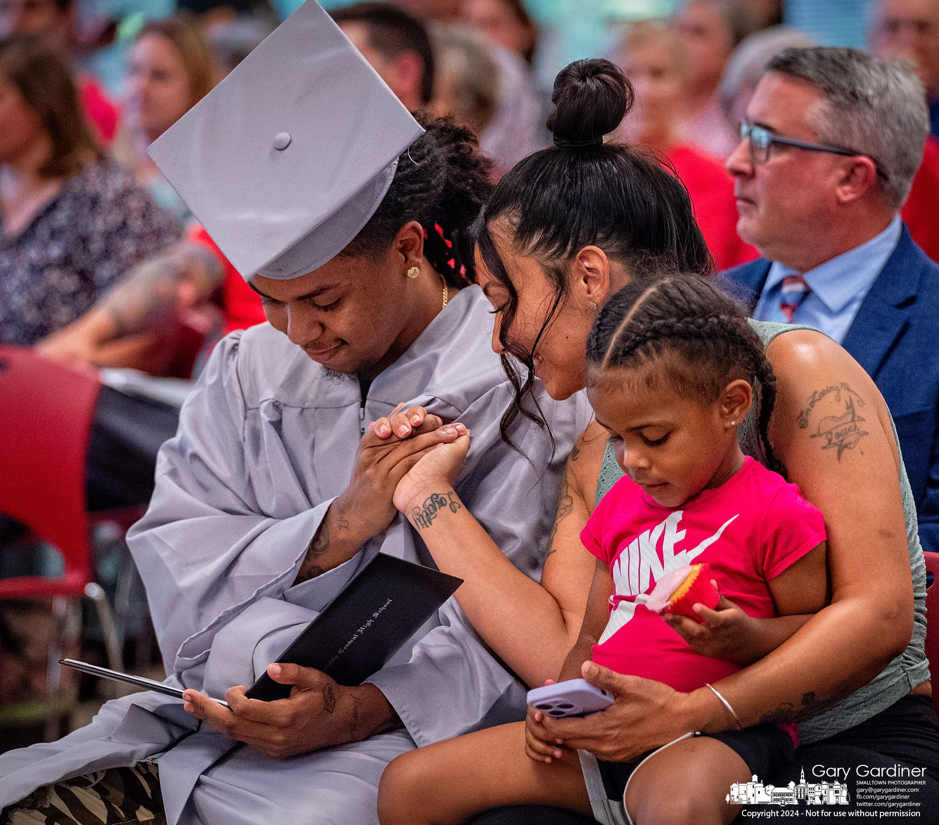 Westerville Central summer graduate Kyon Hayman looks over his graduation certificate as his mother, Cierra Knight, grasps his hand after he received it in ceremonies at the Westerville School Board meeting Monday night. My Final Photo for August 26, 2024.