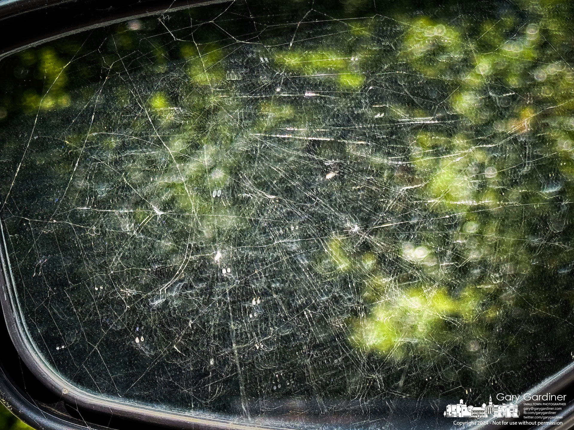 A spider's web is reflected in the driver's side rear-view mirror after several days of being rebuilt from being disturbed during the car owner's photo treks in Westerville. My Final Photo for August 14, 2024.