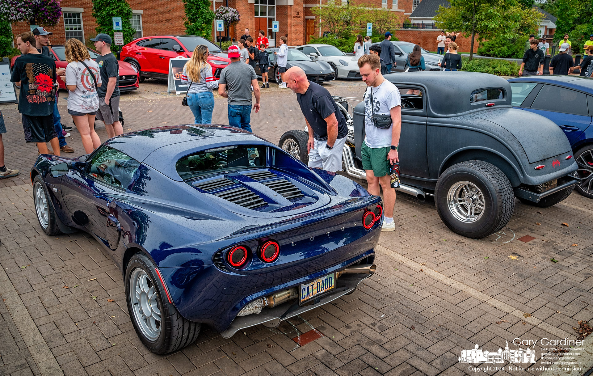 Exotic car fans study a 2019 Lotus Elise parked next to a Model A Ford at the Cars and Coffee meetup behind Westerville City Hall Saturday afternoon. My Final Photo for September 28, 2024.