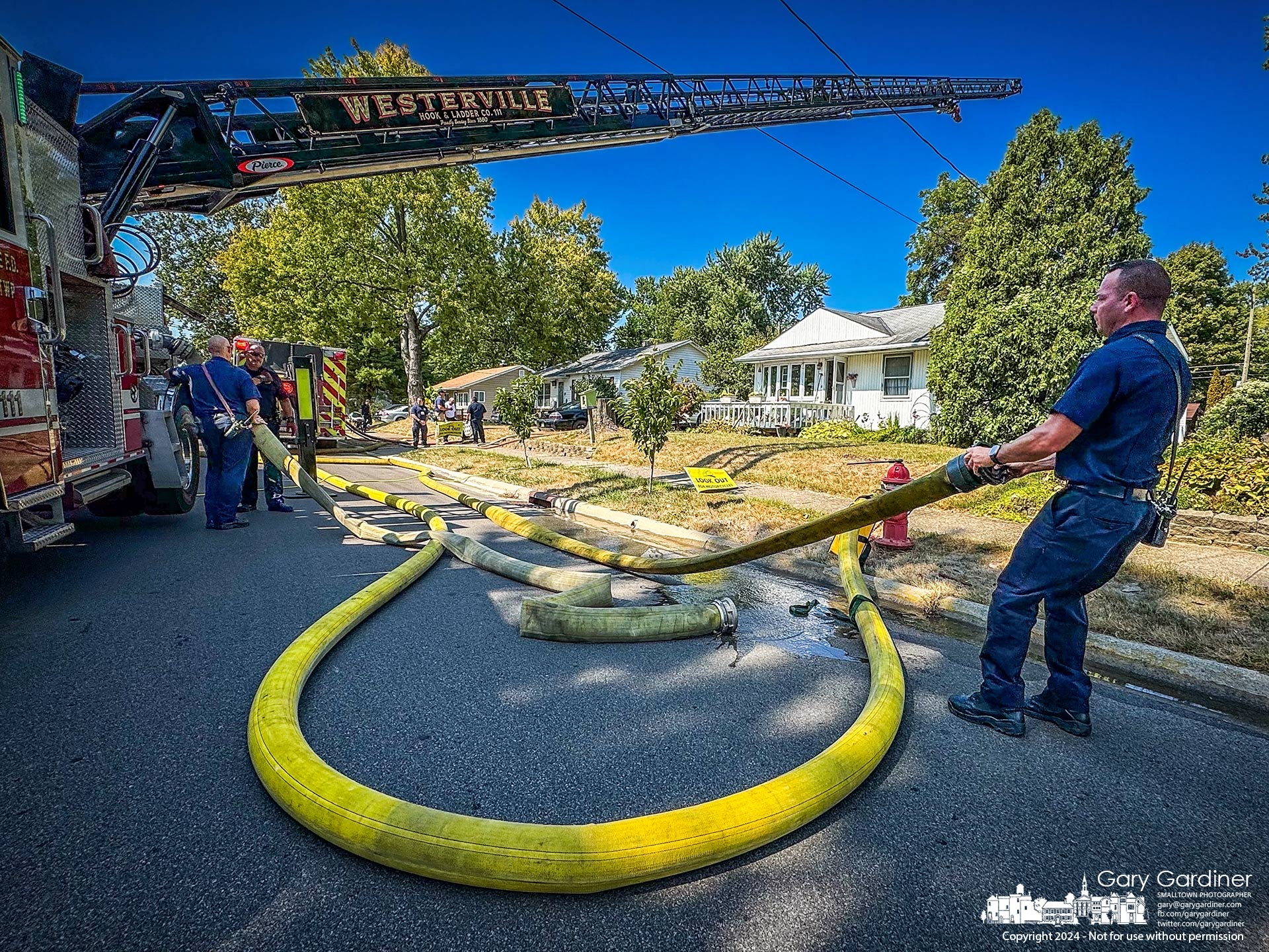 A Westerville firefighter retrieves hoses connecting fire trucks to hydrants at a garage and house fire Sunday afternoon in Westerville. My Final Photo for September 15, 2024.