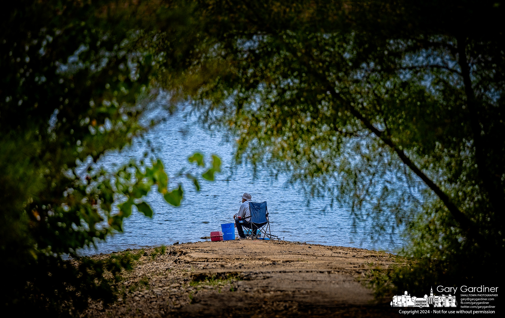 A fisherman sits in his folding fishing chair on the old Walnut Street pavement that once crossed Big Walnut Creek but is now under Hoover Reservoir. My Final Photo for September 26, 2024.