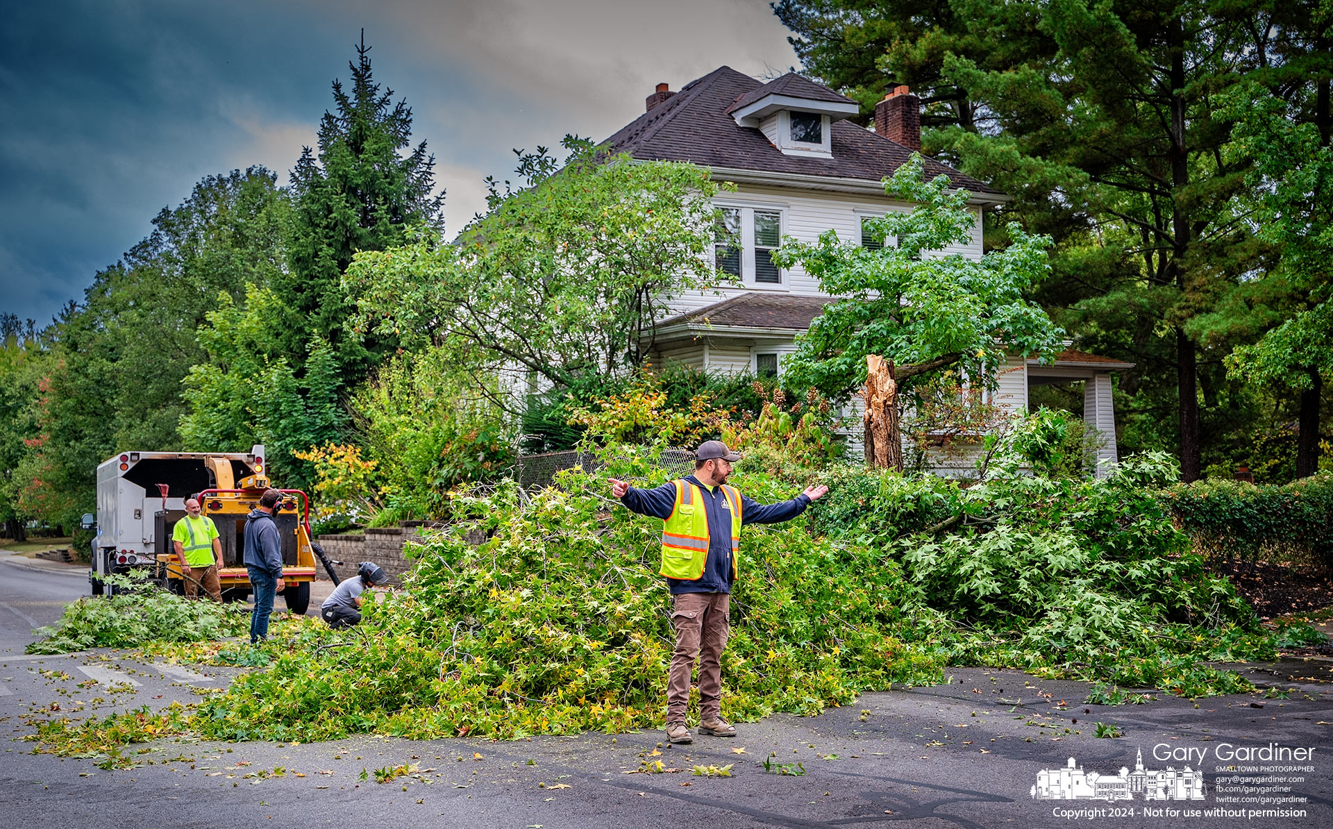 A Westerville service division worker directs traffic around a sweet gum tree being cleared after it fell into the intersection of Otterbein Avenue and East Park Street. My Final Photo for September 24, 2024.