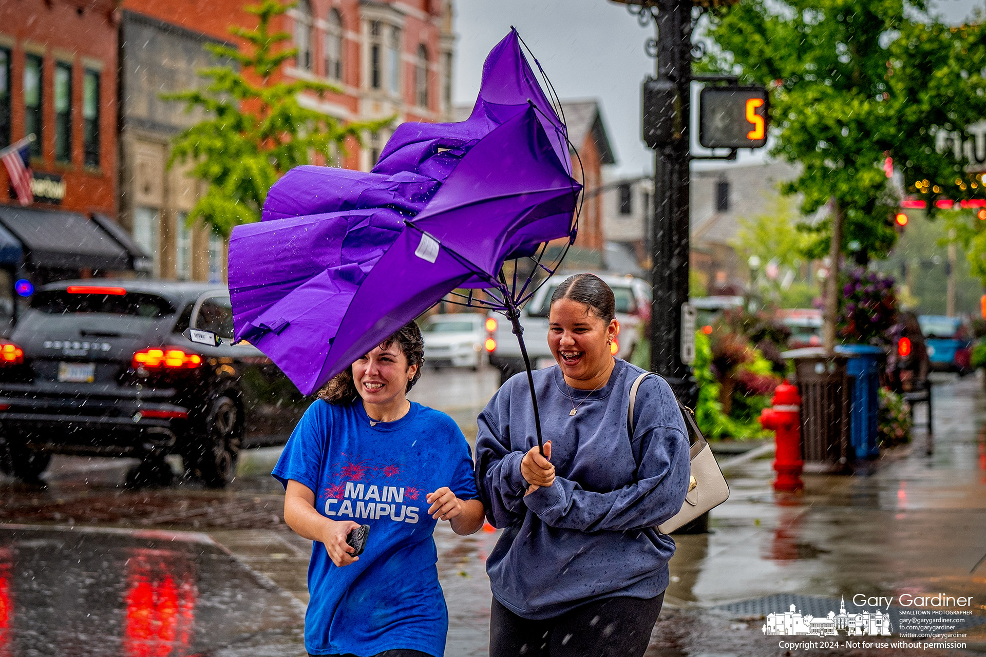 Two women are surprised when their shared umbrella turns inside out as they stepped into the crosswalk at College and Main during Friday afternoon's heavy wind and rain. My Final Photo for September 27, 2024.