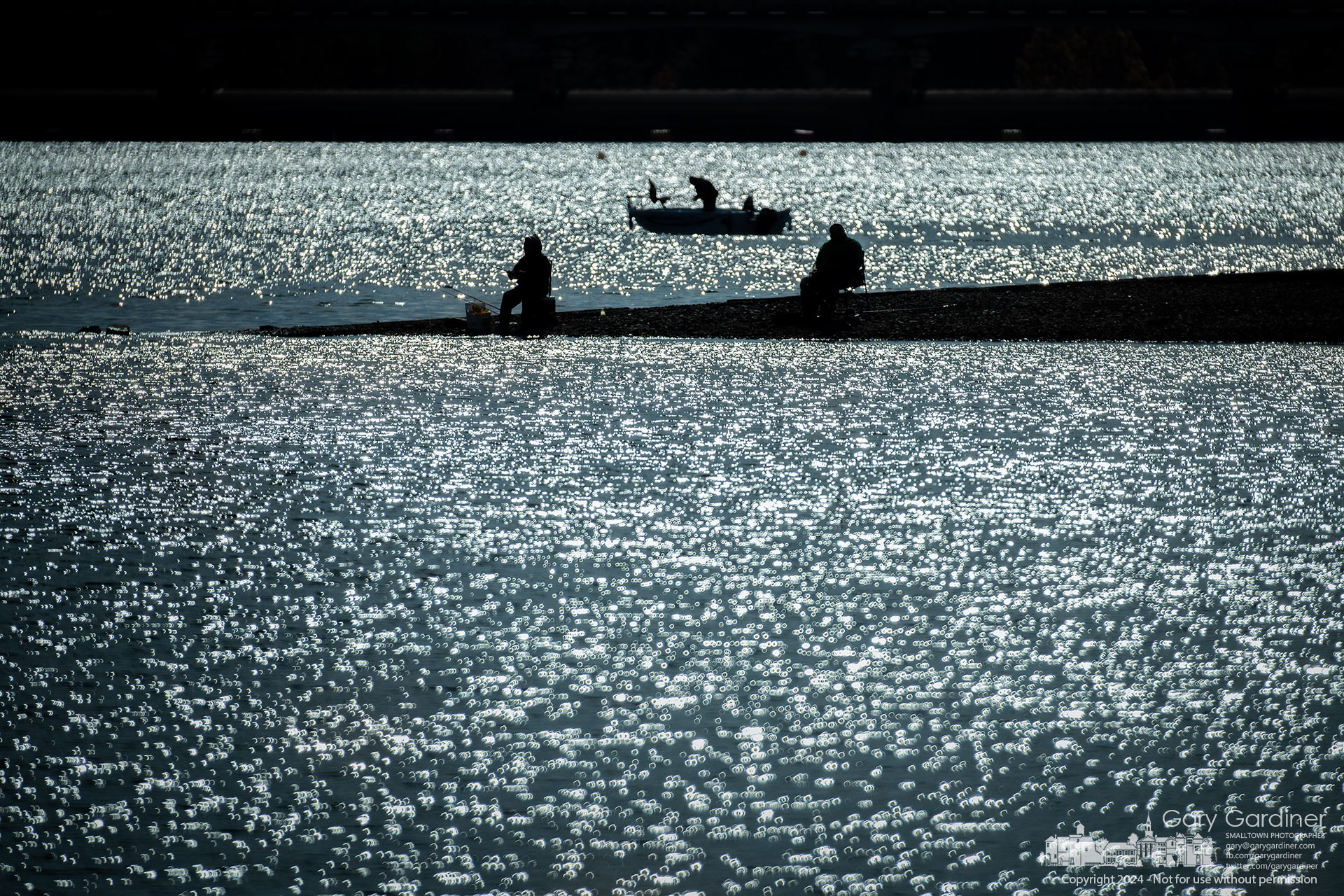 Two fishermen sit on the spit of land that once was Walnut Street, now uncovered by low water levels in Hoover Reservoir, as a third angler configures his lures from a boat. My Final Photo for October 28, 2024.