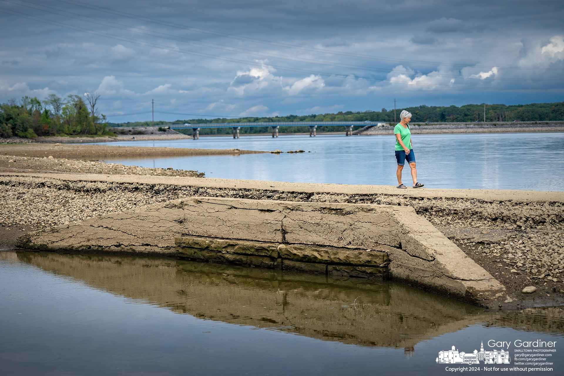 A woman walks across a culvert section of the old, normally submerged Sunbury Road, which is now exposed because of the low water level at Hoover Reservoir. My Final Photo for October 1, 2024.