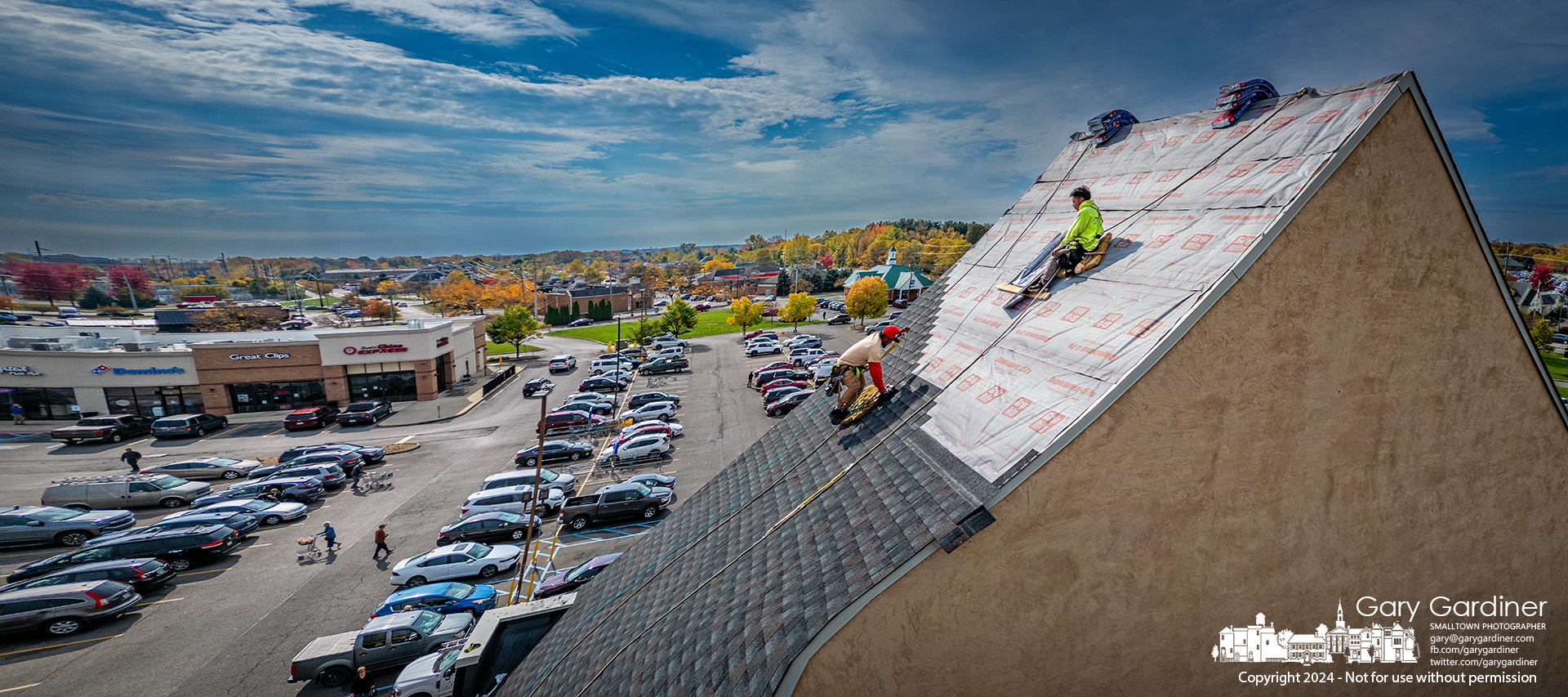 Roofers lay new asphalt shingles on the steep incline over the Kroger store on Maxtown Road. My Final Photo for October 25, 2024.