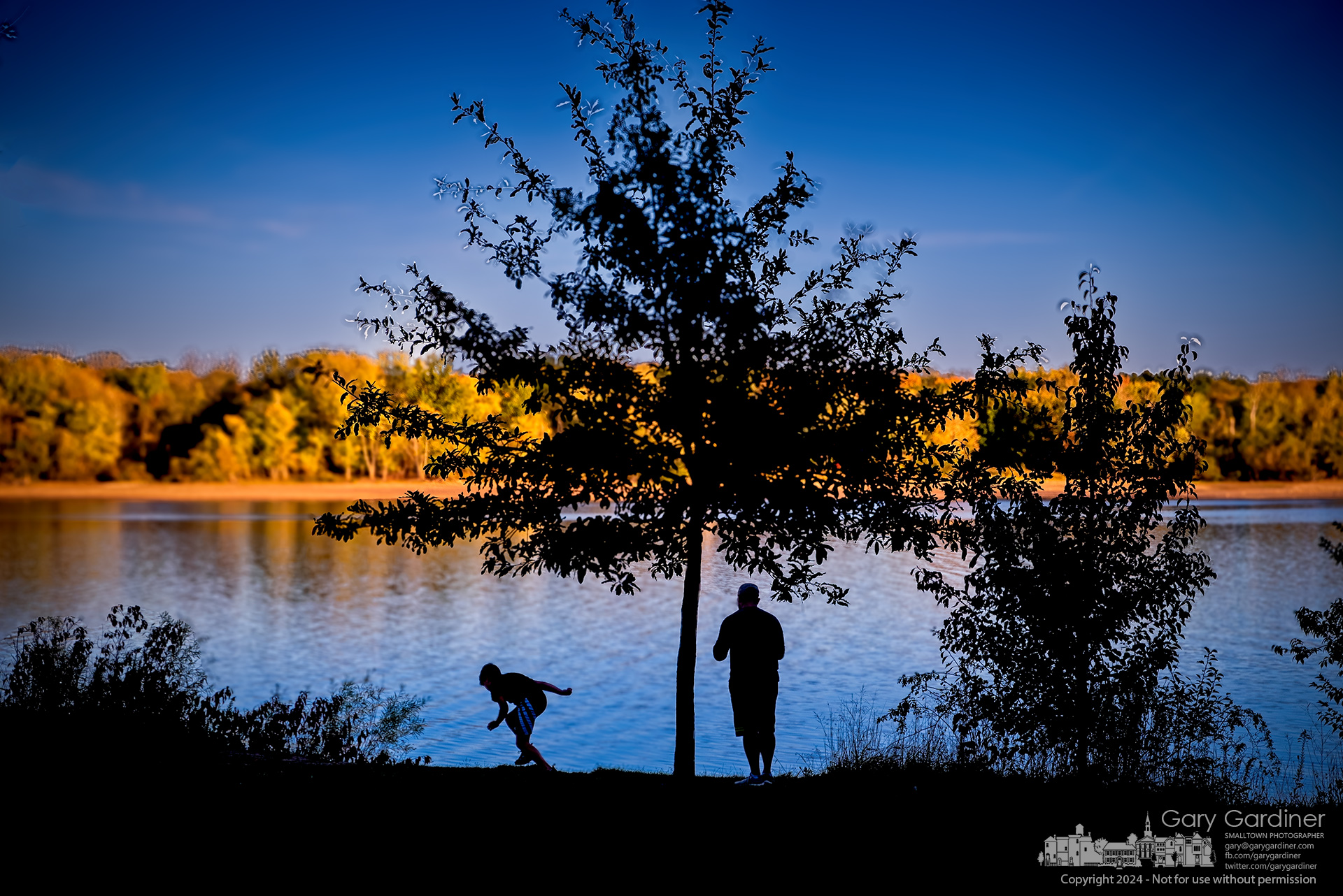 Father and son stand and play at the edge of the high-water mark at Hoover Reservoir enjoying themselves and the view of sunset light hitting the eastern shoreline. My Final Photo for October 19, 2024.