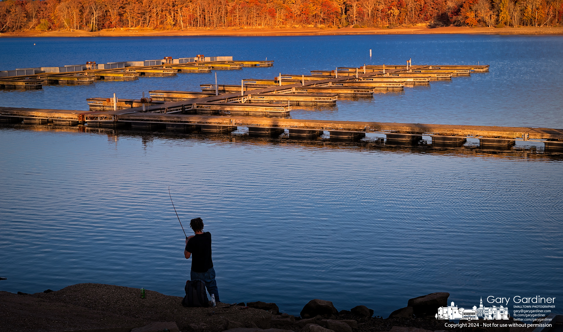 A fisherman stands in the cool shadows of Hoover Reservoir as the setting sun casts its golden light across the empty docks and eastern shore. My Final Photo for November 3, 2024.