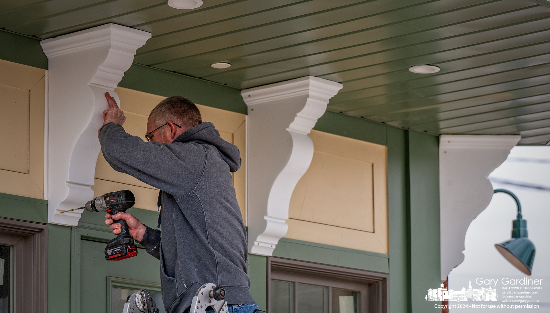 A carpenter attaches decorative frieze brackets to the entrance of Ampersand restaurant being built on West College Ave. in Uptown Westerville. My Final Photo for December 19, 2024.