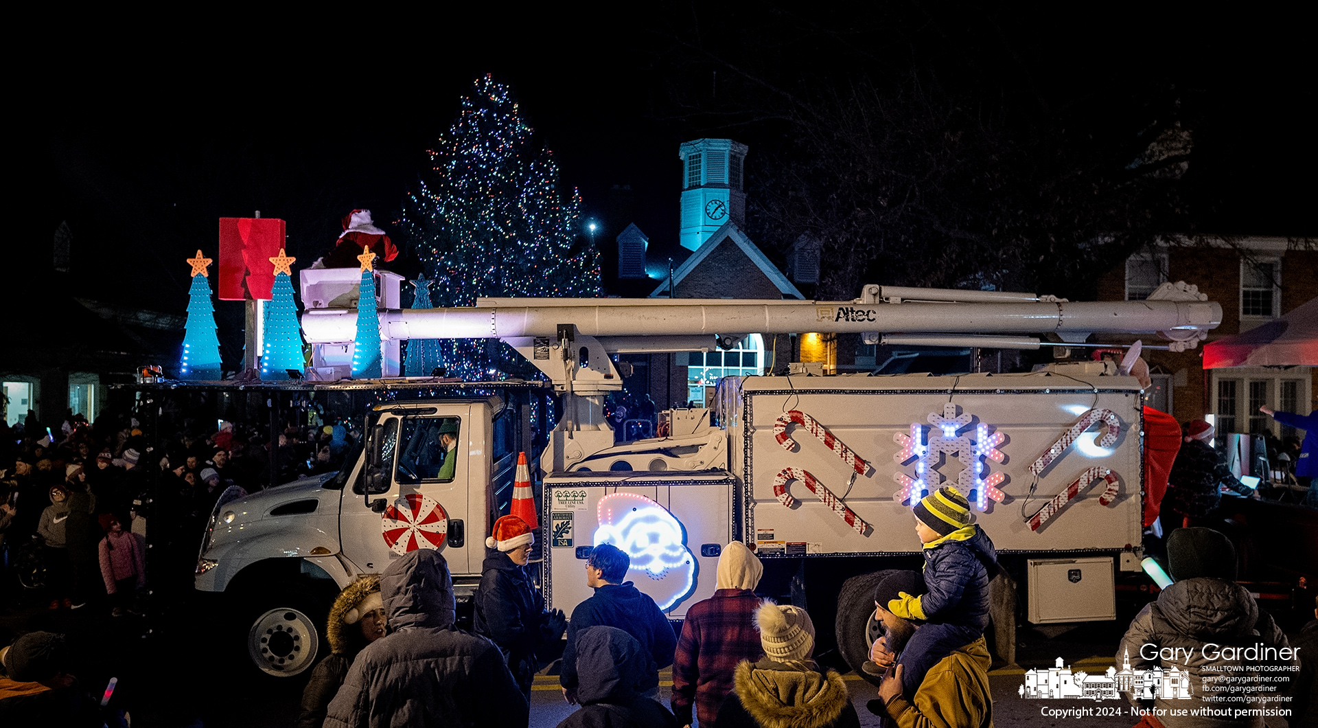 Santa stands in his diesel-powered bucket truck sleigh after overseeing the holiday tree lighting in front of city hall Friday night. My Final Photo for December 6, 2024.