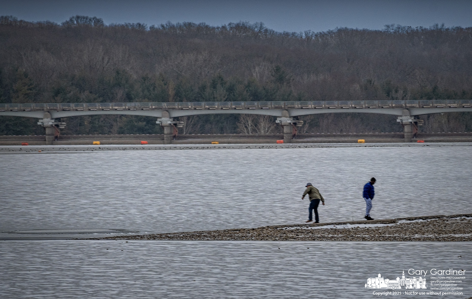 A man stretches to add energy to his final demonstration of skipping stones across the frozen lake at Hoover Reservoir. My Final Photo for January 19, 2025.