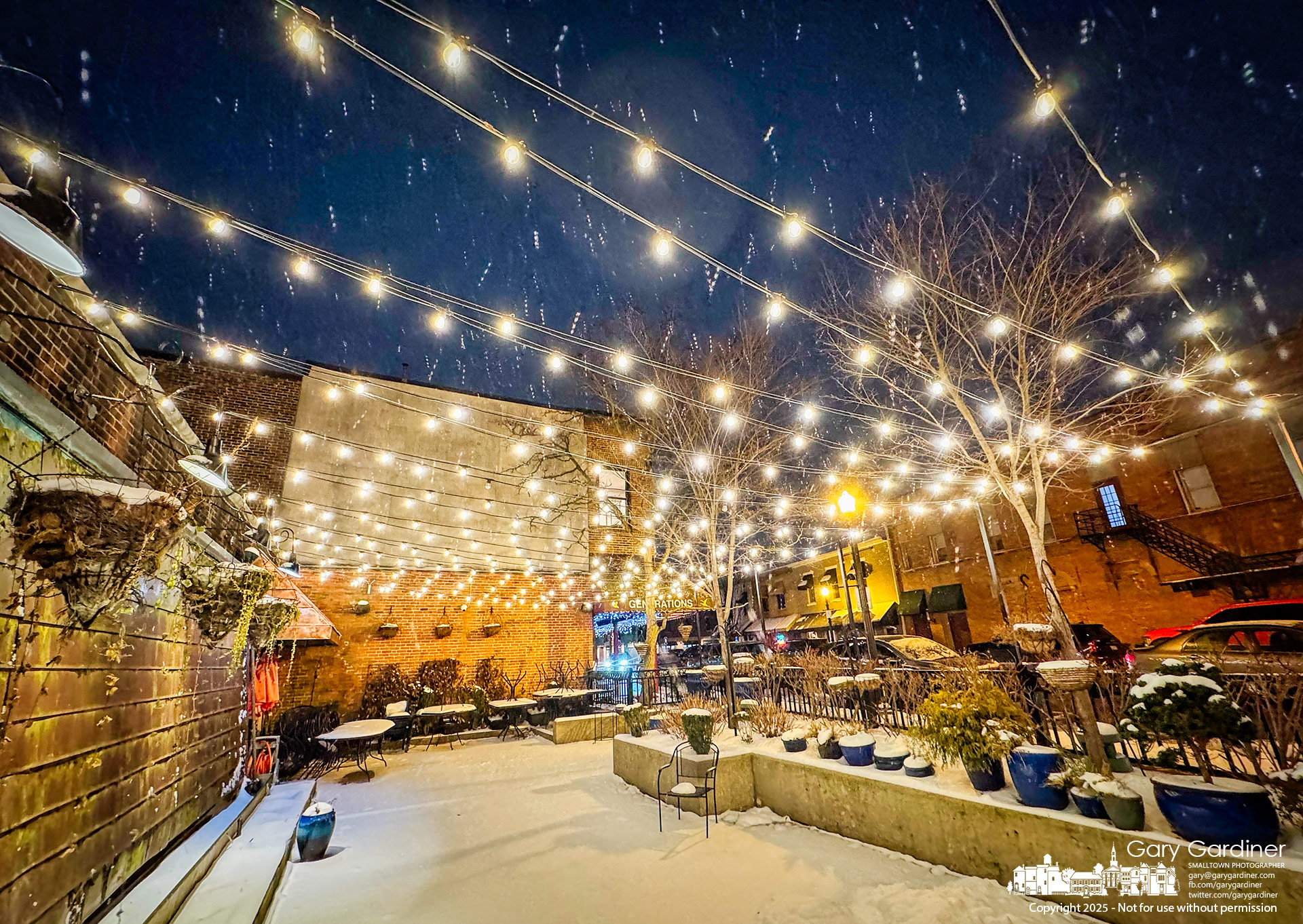 Light snow flurries fall across Jimmy V's brightly lit closed patio, reminding frozen Uptown Westerville of warmer times, good food, and companionship. My Final Photo for January 8, 2025.