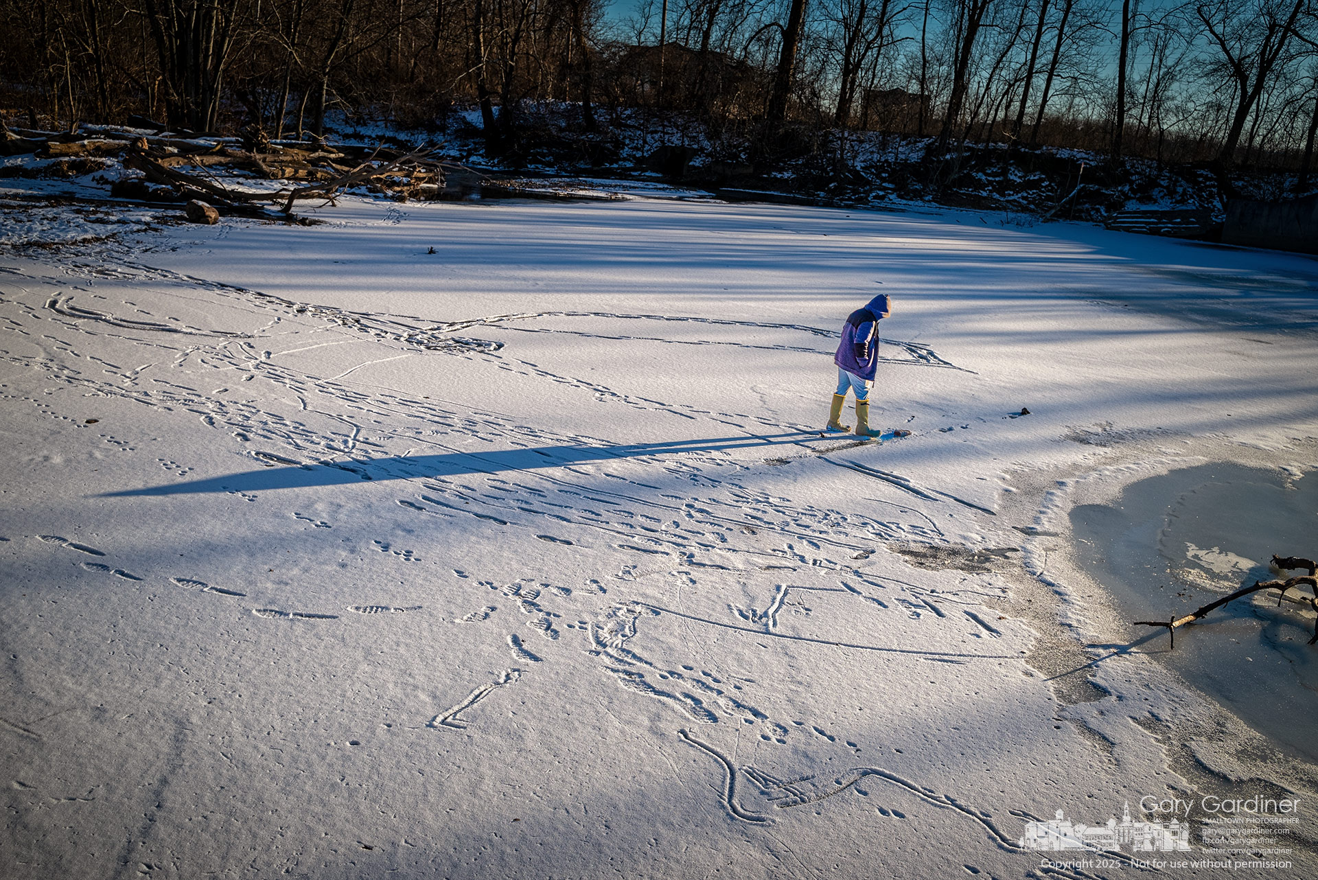 Stephen Earl retraces his earlier steps across the frozen waters below the dam at Alum Creek Park North in Westerville. My Final Photo for January 27, 2025.